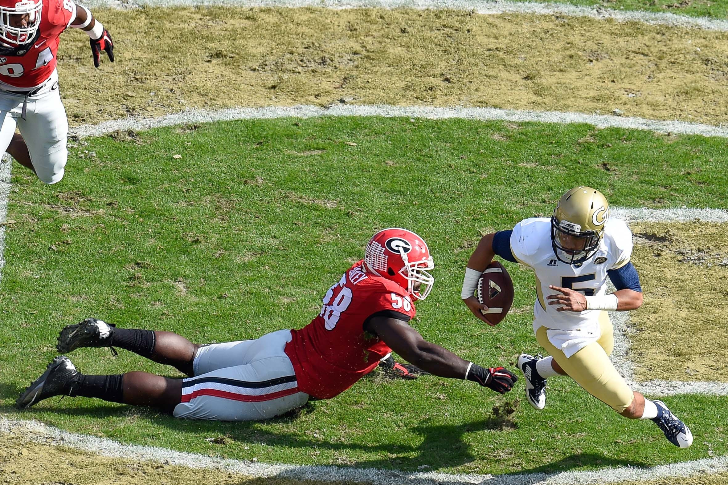 Georgia Tech Yellow Jackets quarterback Justin Thomas (5) escapes a tackle by Georgia Bulldogs defensive tackle Sterling Bailey (58) during the first quarter at Bobby Dodd Stadium. Dale Zanine-USA TODAY Sports