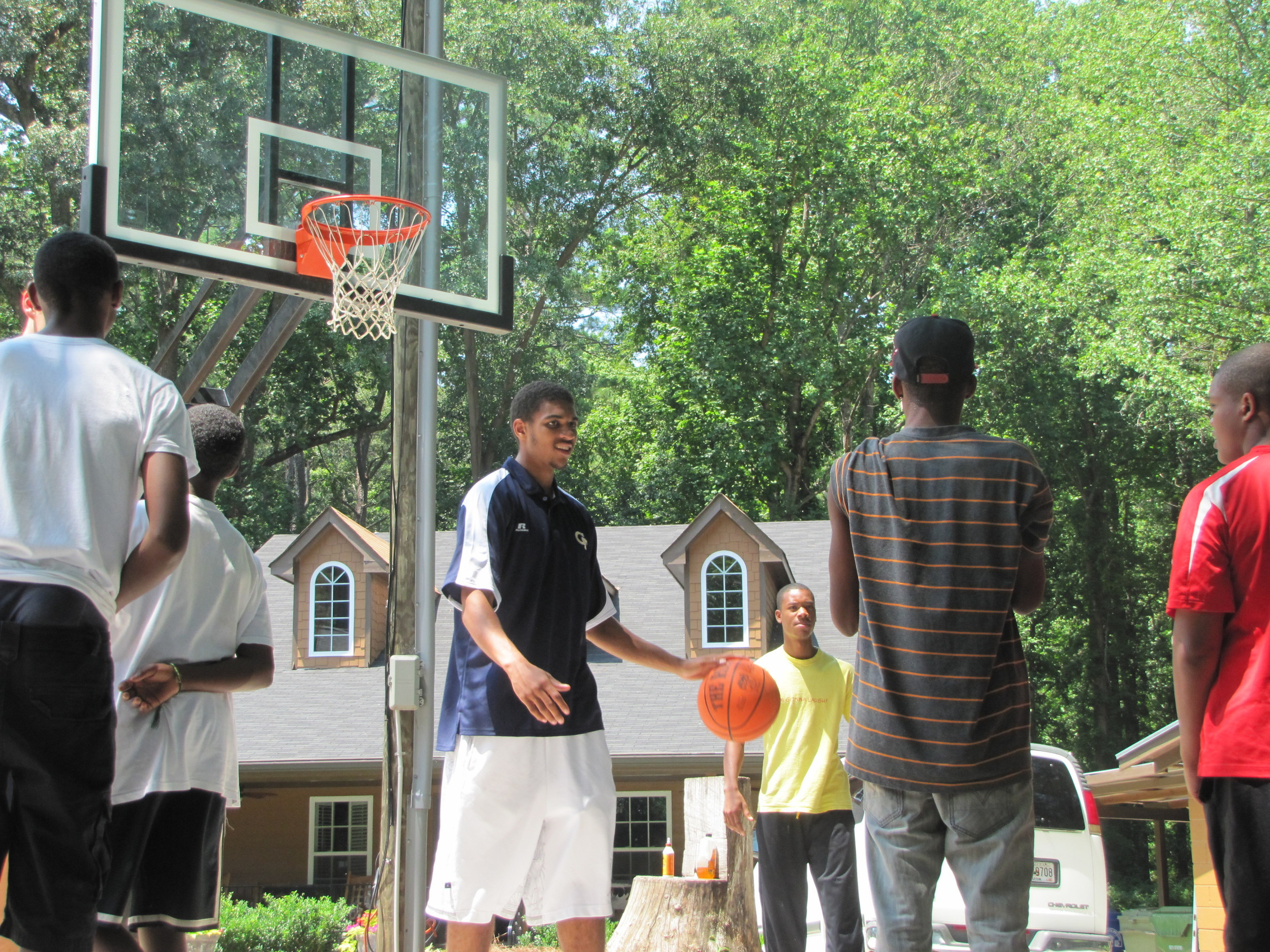 Kammeon Holsey, Daniel Miller, Brandon Reed and Glen Rice. Jr., play pick-up with the kids at Bright Futures Academy.