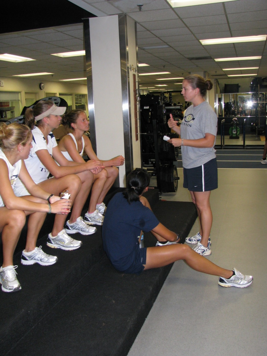 Strength coach Tiffany Allen speaks with members of women's tennis team