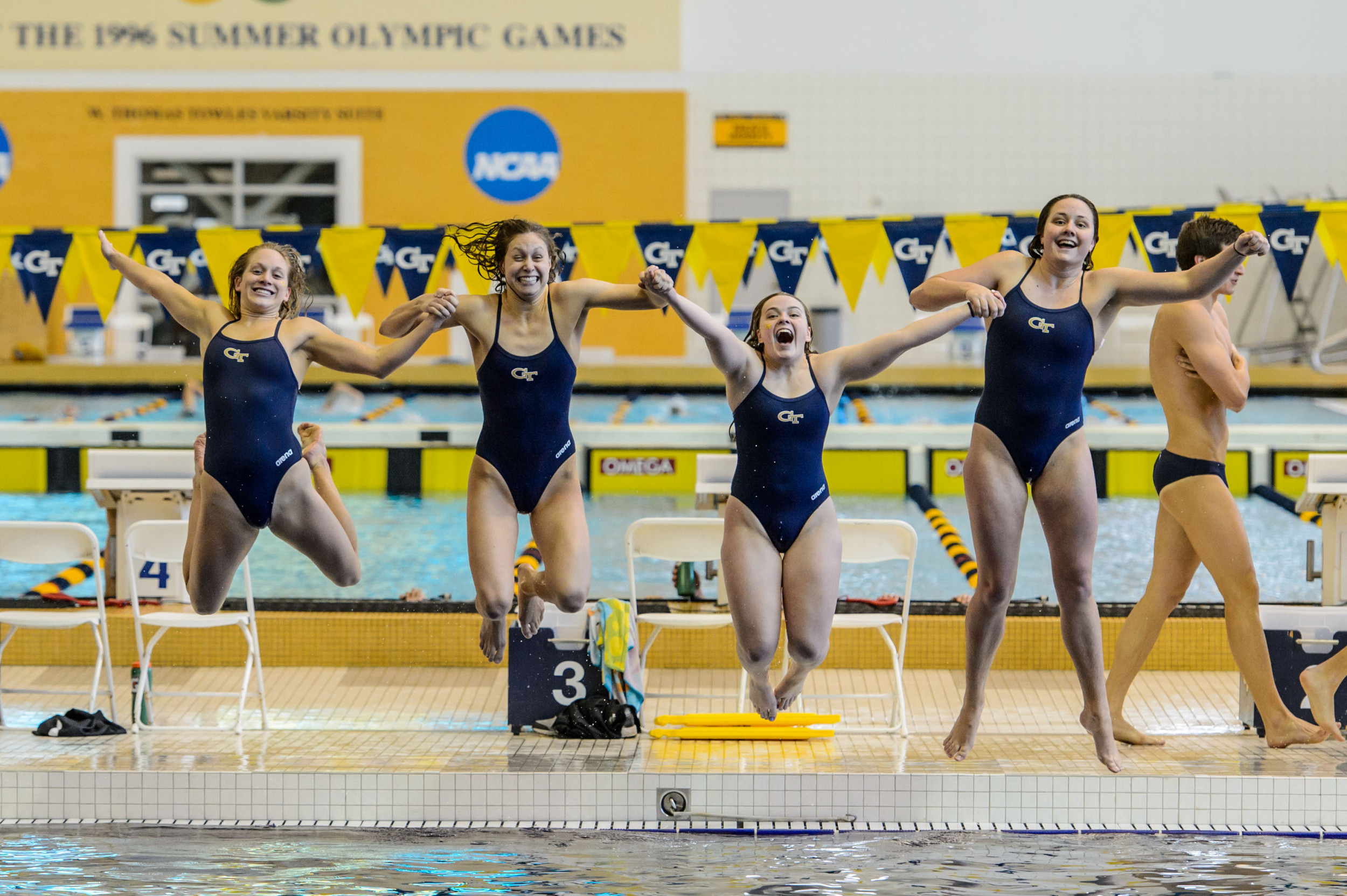 Seniors Kate Brandus, Kelsey Maloney, Catherine Richards, Kate Woolbright leap into the pool at the end of the meet
