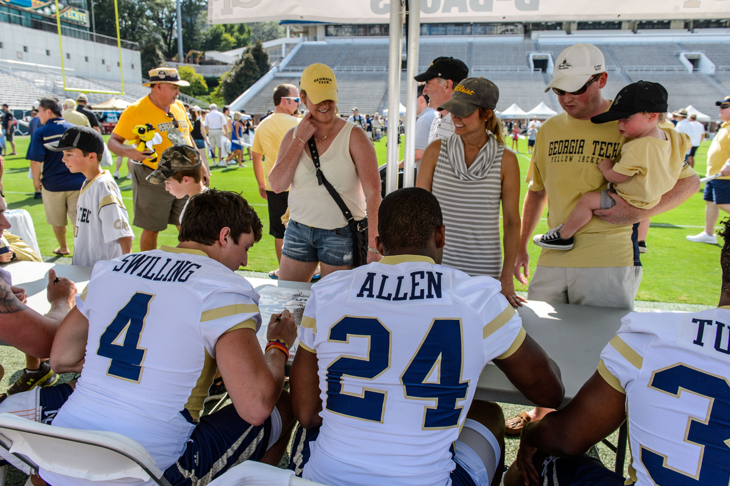 Marcus Allen (24) and Brady Swilling (4) sign autographs