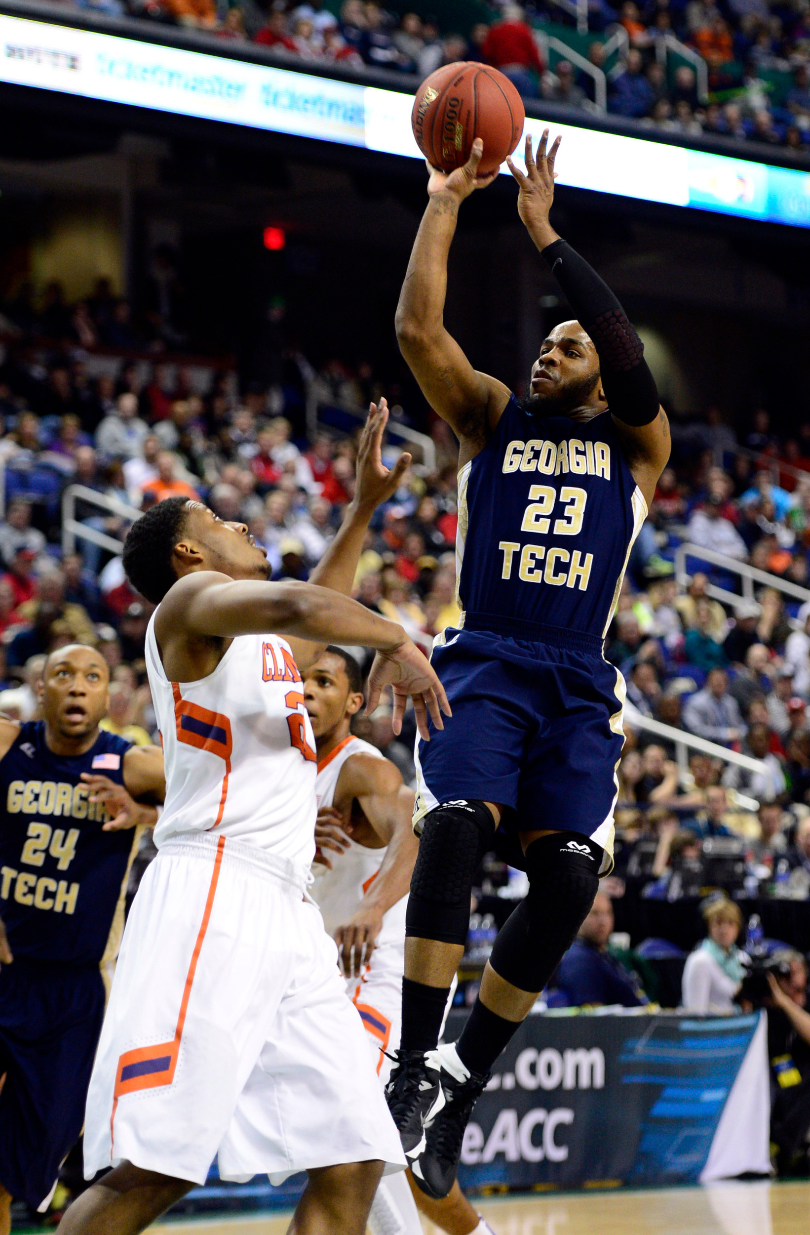 Mar 13, 2014; Greensboro, NC, USA; Georgia Tech Yellow Jackets guard Trae Golden (23) takes a jump shot over Clemson Tigers guard Damarcus Harrison (21) in the second round of the ACC college basketball tournament at Greensboro Coliseum. Mandatory Credit: John David Mercer-USA TODAY Sports