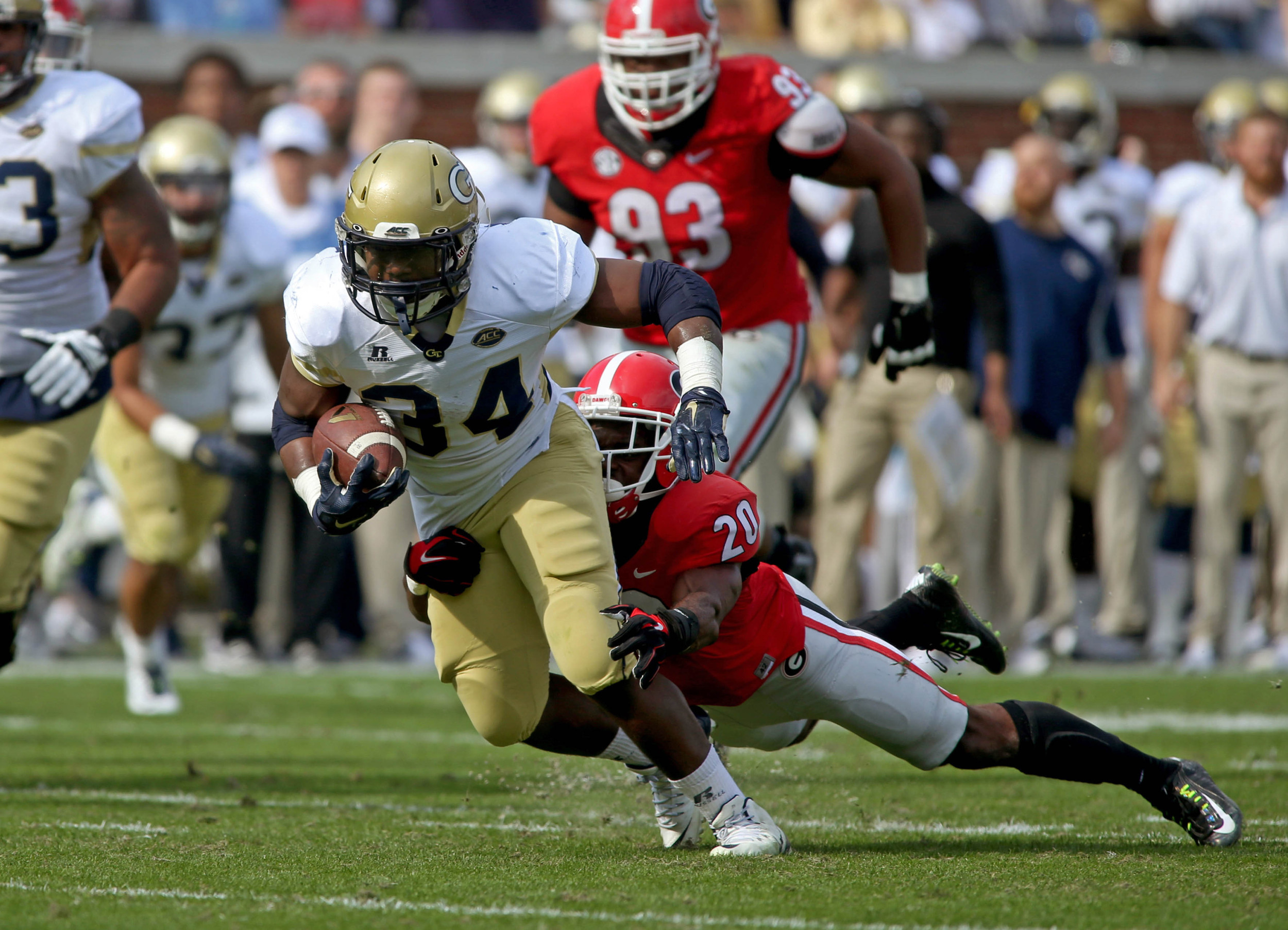 Georgia Tech Yellow Jackets running back Marcus Marshall (34) is tackled by Georgia Bulldogs safety Quincy Mauger (20) in the second quarter of their game at Bobby Dodd Stadium. Jason Getz-USA TODAY Sports