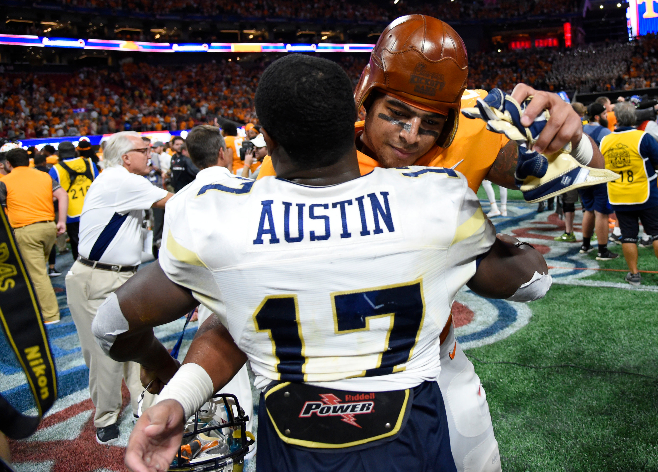 Sep 4, 2017; Atlanta, GA, USA; Tennessee Volunteers linebacker Cortez McDowell (20) embraces Georgia Tech Yellow Jackets defensive back Lance Austin (17) while wearing the old leather helmet after a game at Mercedes-Benz Stadium. Tennessee won 42-41 in two overtimes. Mandatory Credit: Dale Zanine-USA TODAY Sports