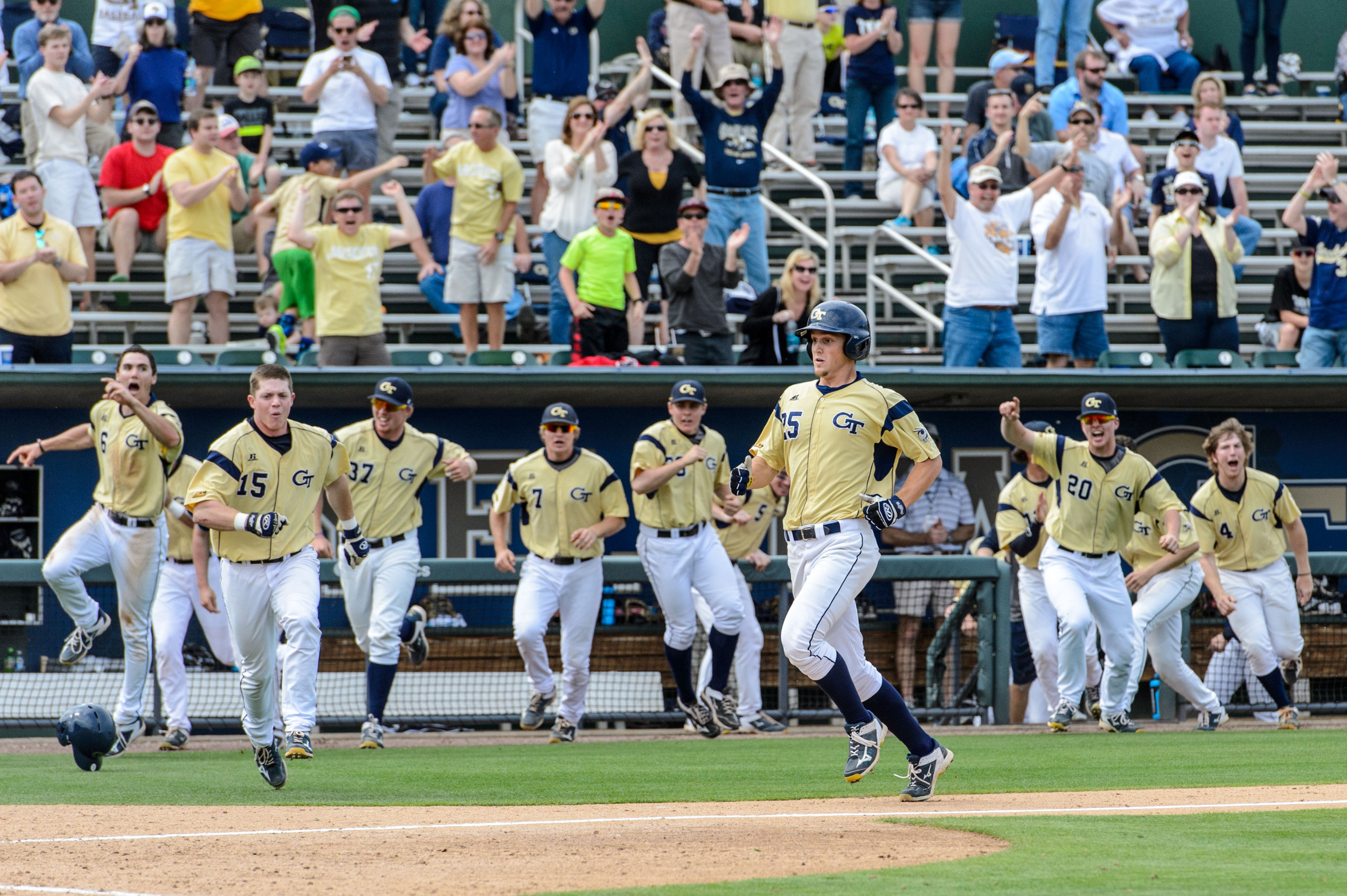 Kel Johnson (25) runs in to score the winning run while the crowd and team celebrate