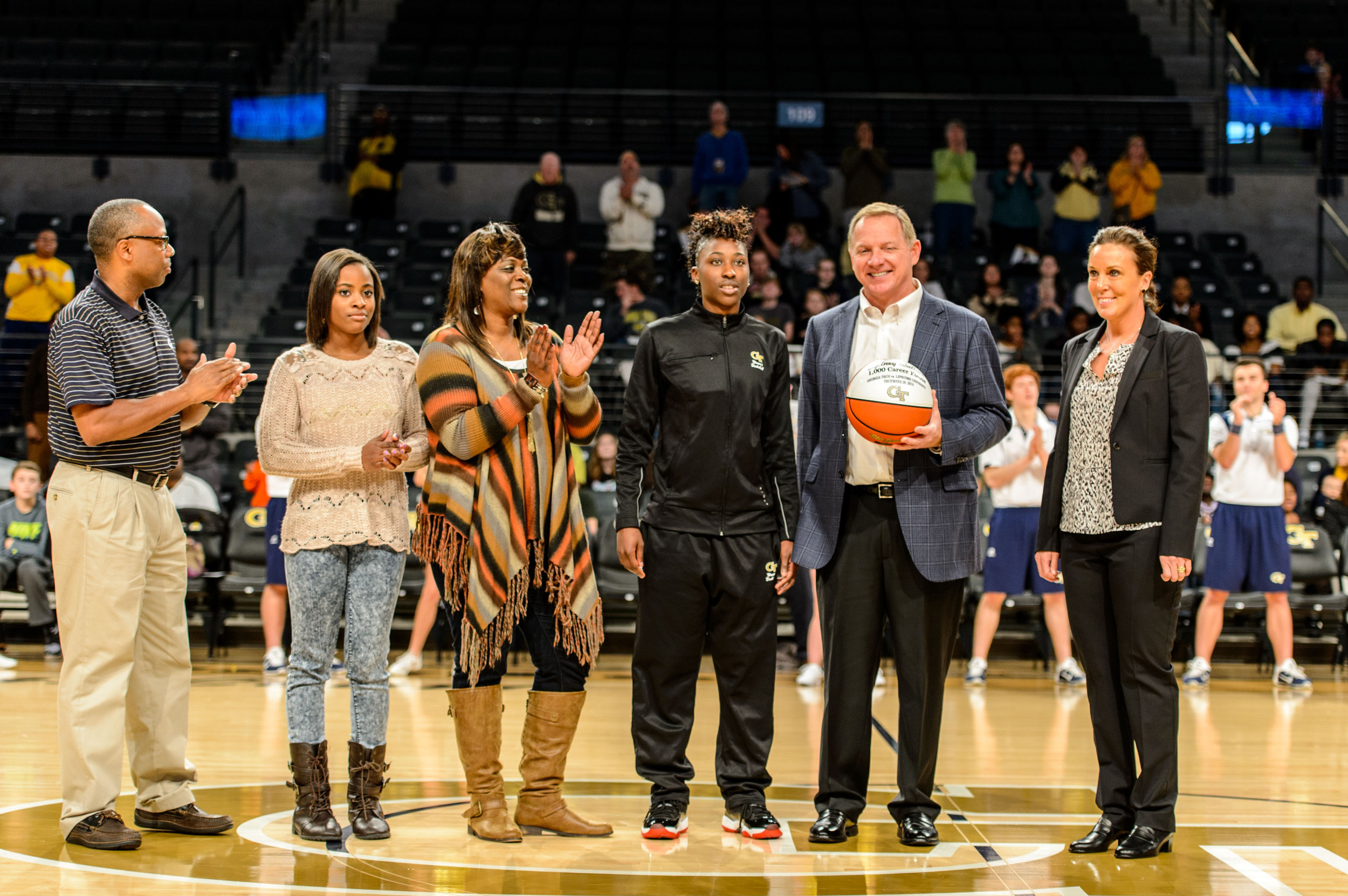 Coach MaChelle Joseph and Athletic Director Mike Bobinski present Sydney Wallace (23) and her family with a ball recognizing her reaching 1000 career points with the Yellow Jackets