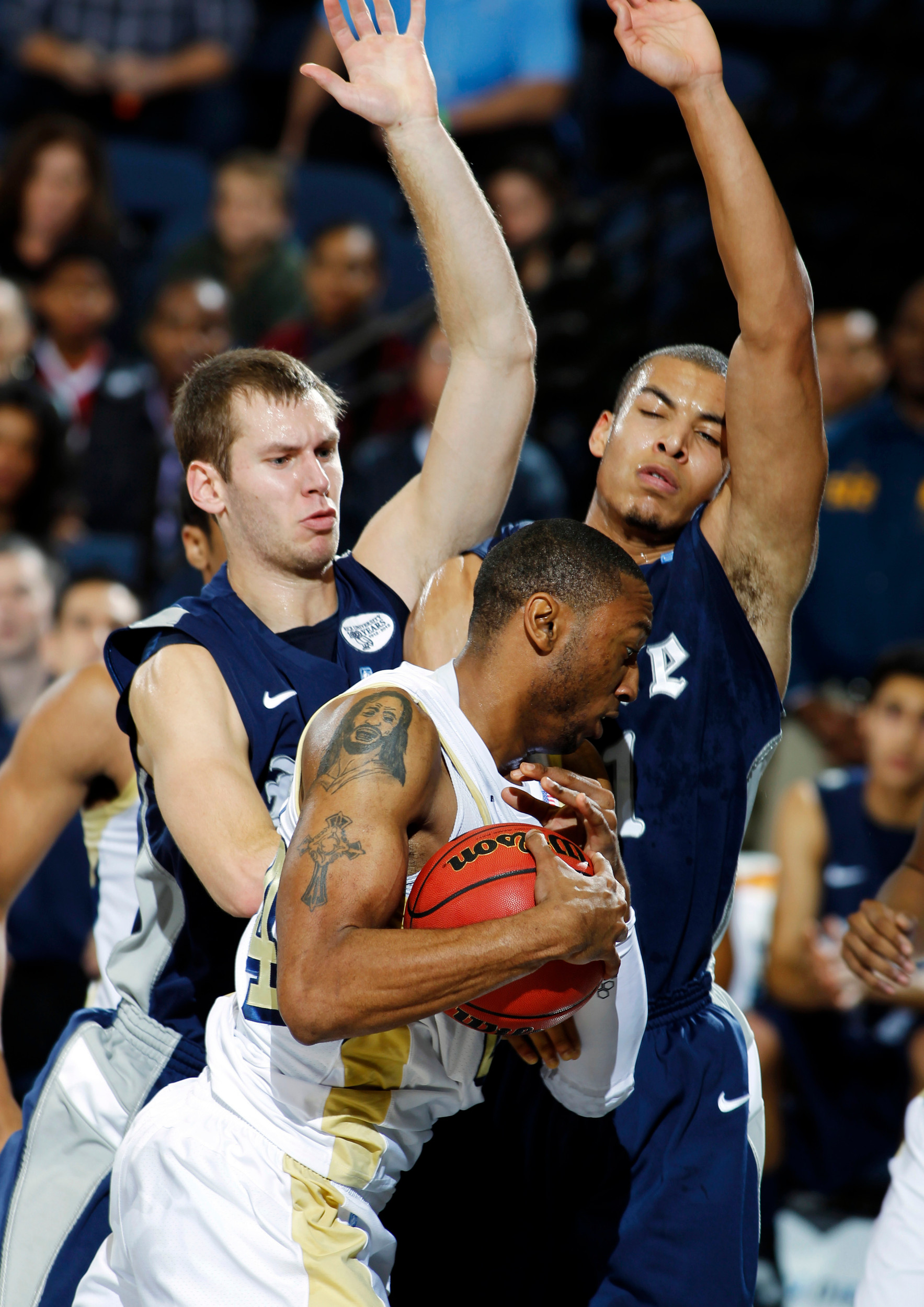 Rice forward Seth Gearhart, left, and forward Ross Wilson, right, defend Georgia Tech forward Kammeon Holsey. (AP Photo/Alex Gallardo)