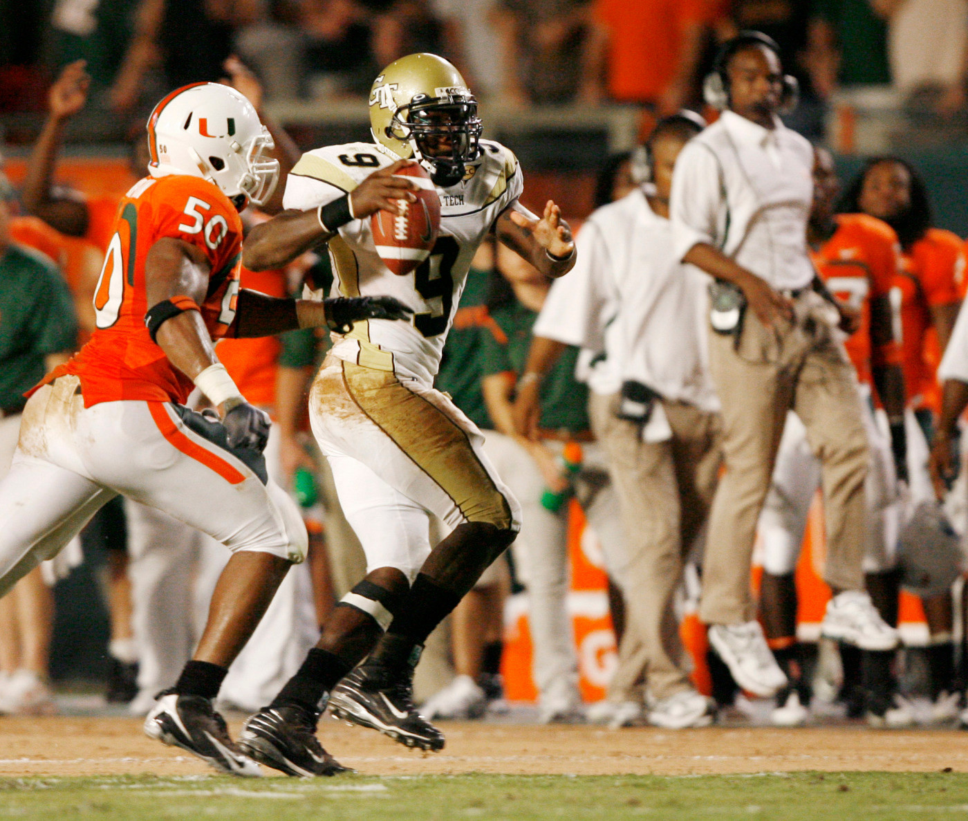 Miami's Darryl Sharpton (50), runs down Georgia Tech quarterback Josh Nesbitt (9) as Miami head coach Randy Shannon reacts in the background during the first quarter of an NCAA college football game Thursday, Sept. 17, 2009, in Miami. Byrd caught the pass and ran in for a touchdown. (AP Photo/Hans Deryk)