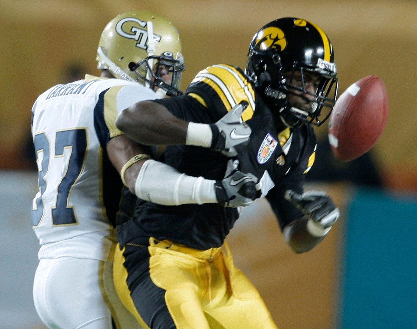 Iowa wide receiver Marvin McNutt (7) fumbles the ball as he is tackled by Georgia Tech's Jerrard Tarrant (37) during the first quarter of the Orange Bowl NCAA college football game Tuesday, Jan. 5, 2010, in Miami. Georgia Tech recovered the fumble. (AP Photo/Lynne Sladky)