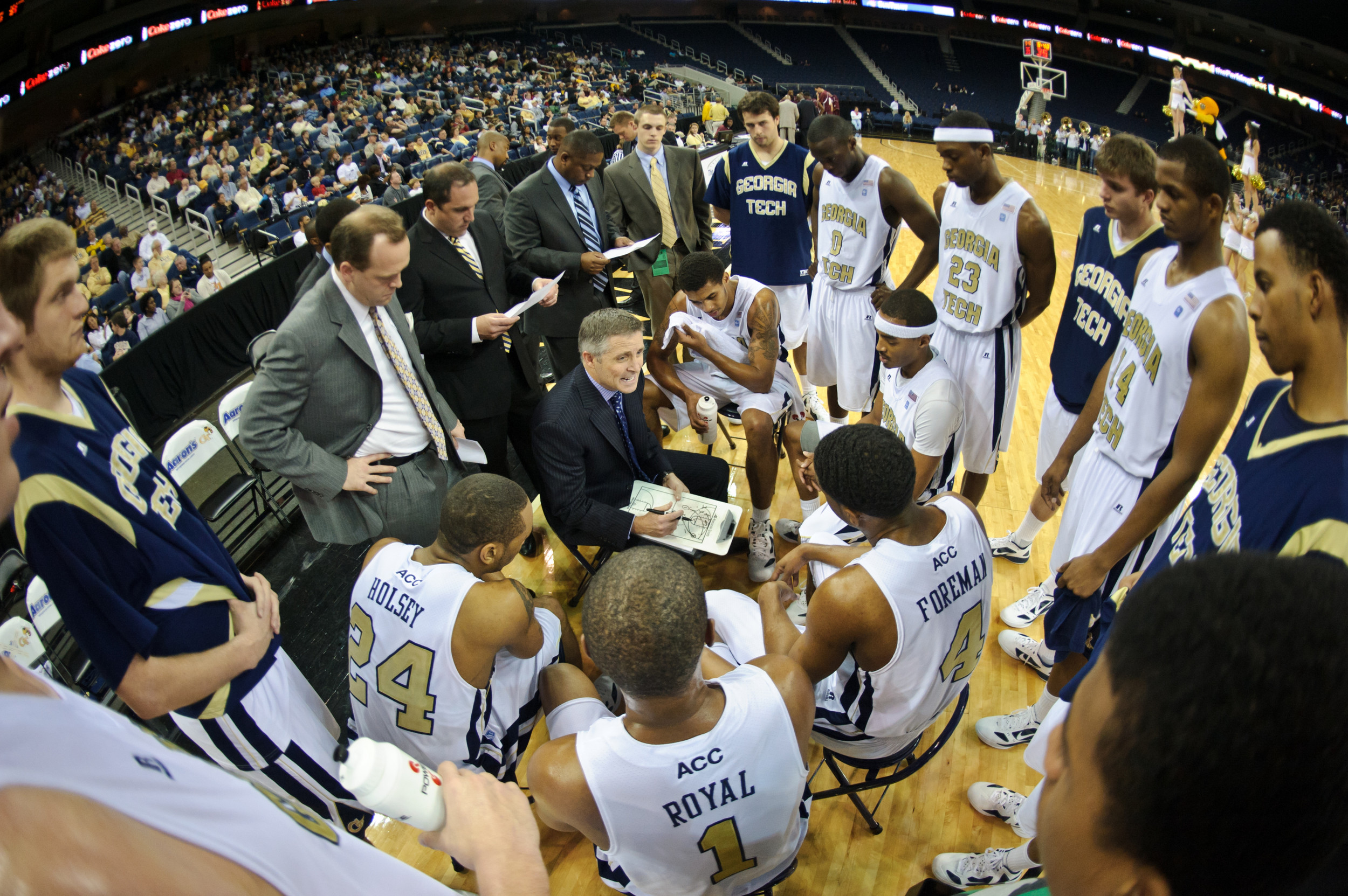 Coach Brian Gregory draws up a play for the team in the huddle during a timeout.
