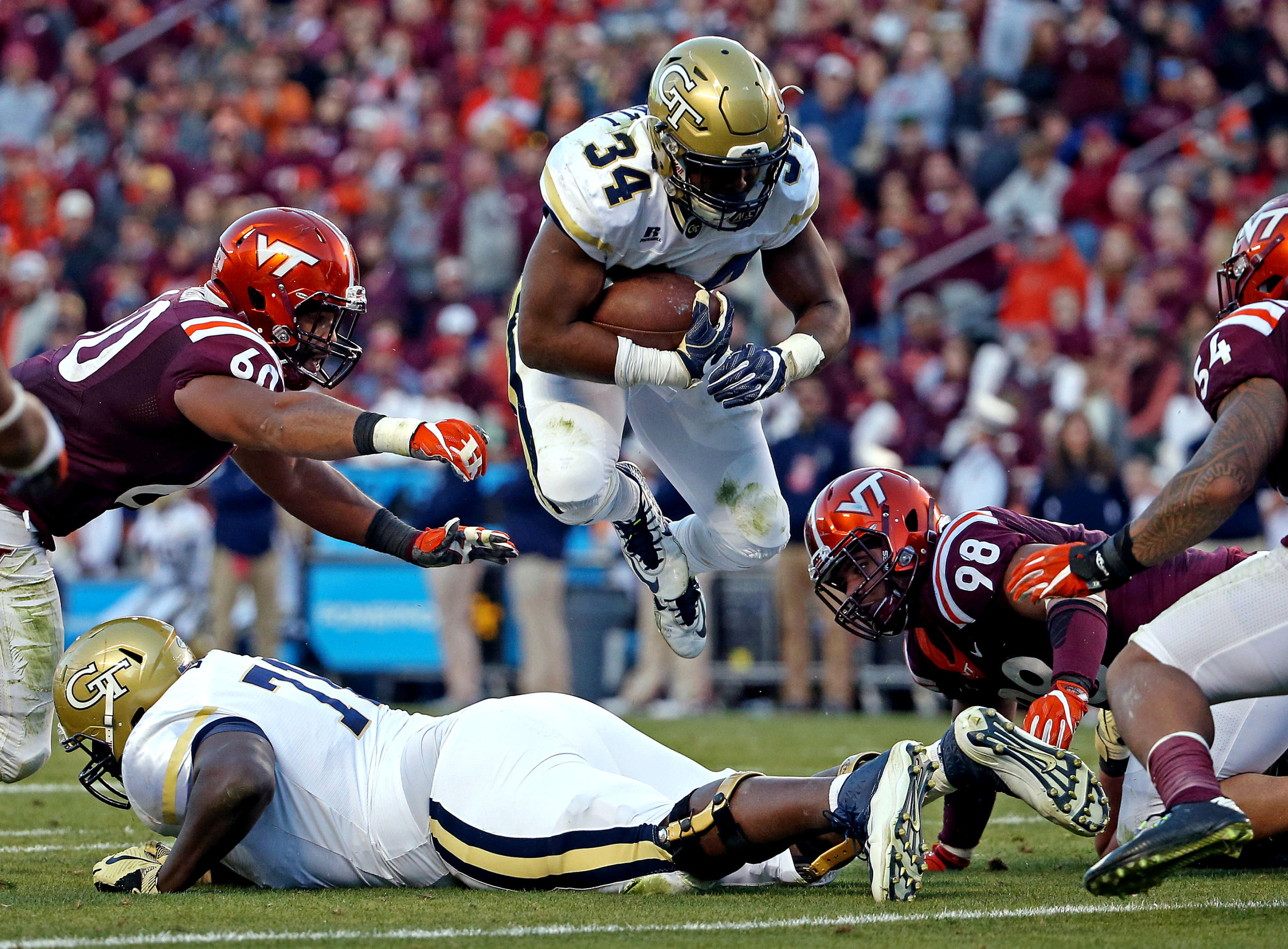 Blacksburg, VA; Georgia Tech Yellow Jackets running back Marcus Marshall jumps over offensive lineman Shamire Devine during the second quarter at Lane Stadium. Credit: Peter Casey-USA TODAY Sports