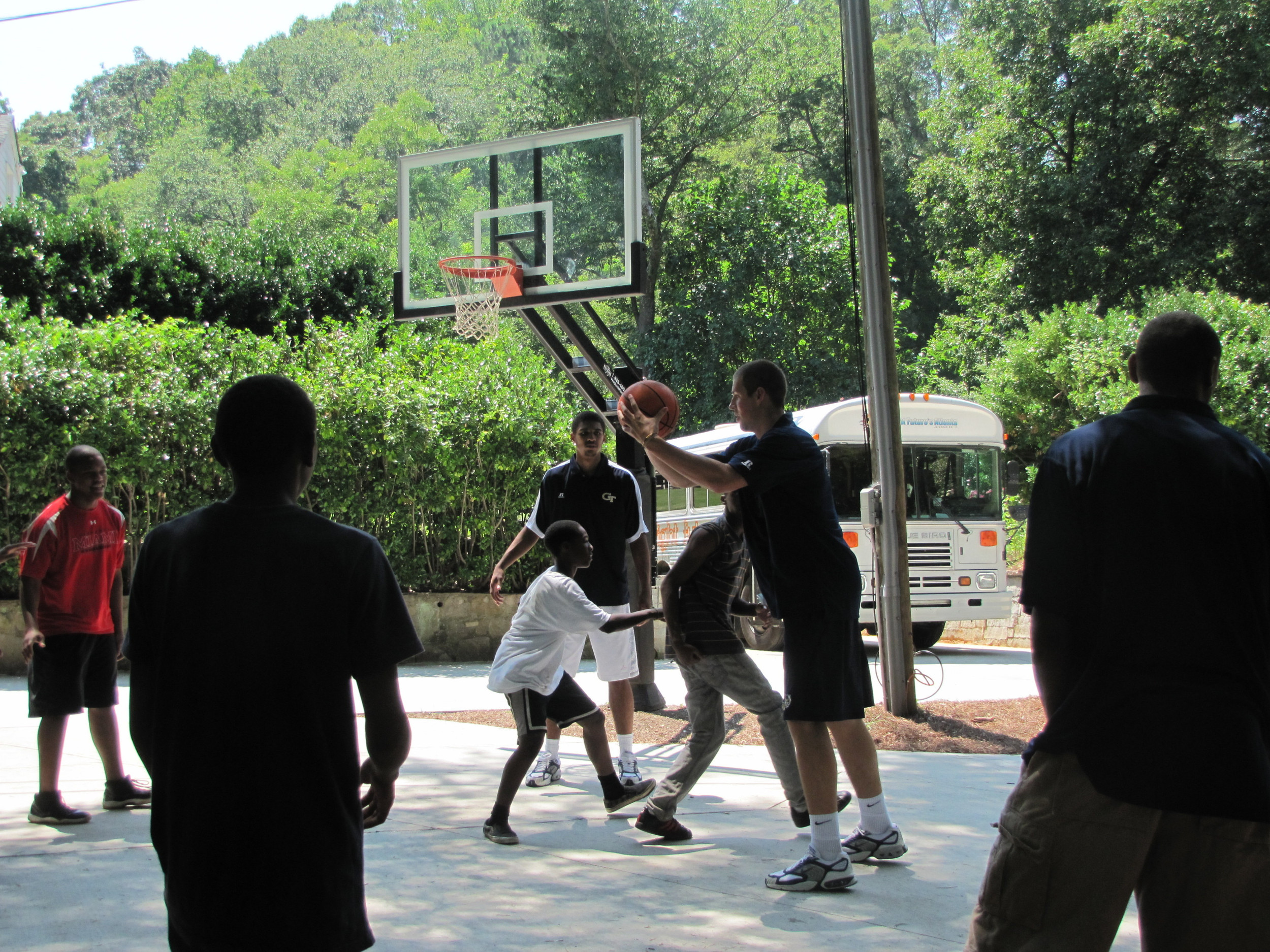 Kammeon Holsey, Daniel Miller, Brandon Reed and Glen Rice. Jr., play pick-up with the kids at Bright Futures Academy.