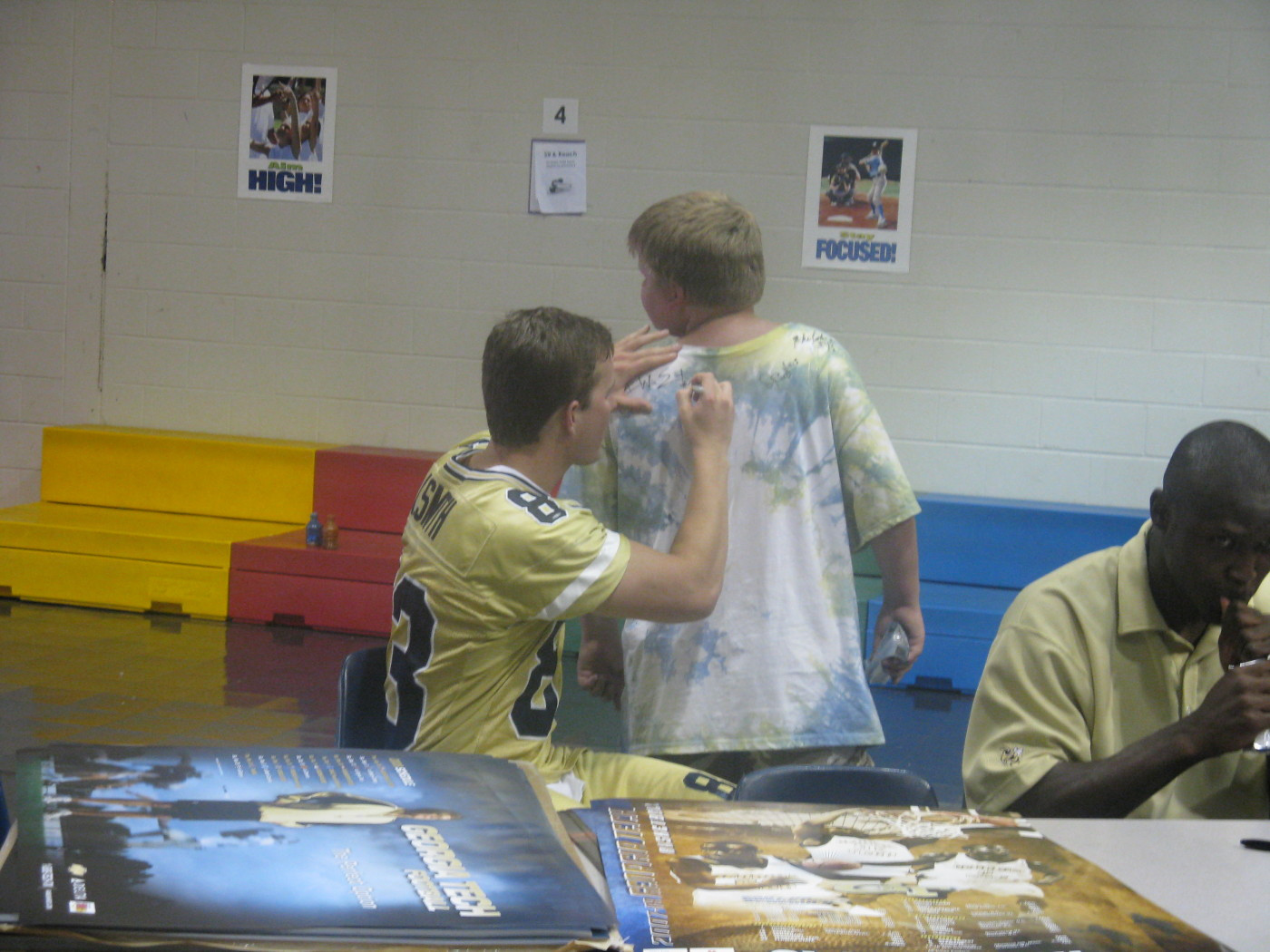 Andrew Smith signs the back of a student's shirt.