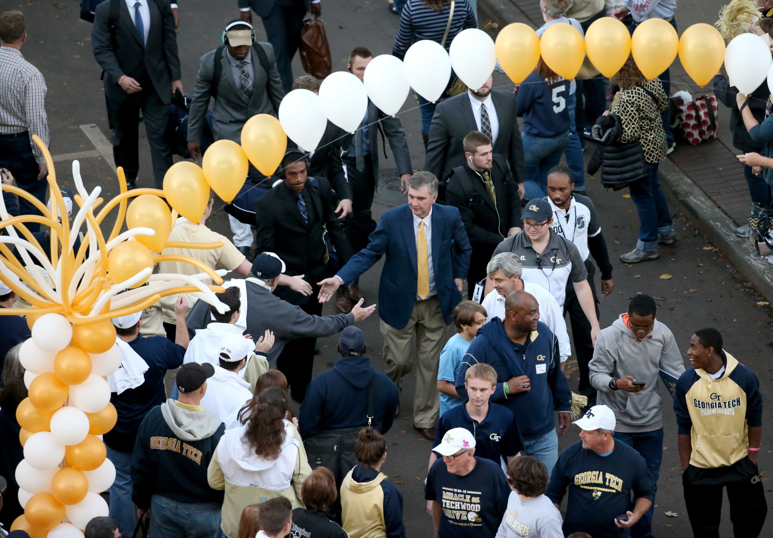 Head coach Paul Johnson (center) greets fans as he walks with the team toward Bobby Dodd Stadium before the game against the Virginia Tech Hokies (Garrett Reid-USA TODAY Sports)