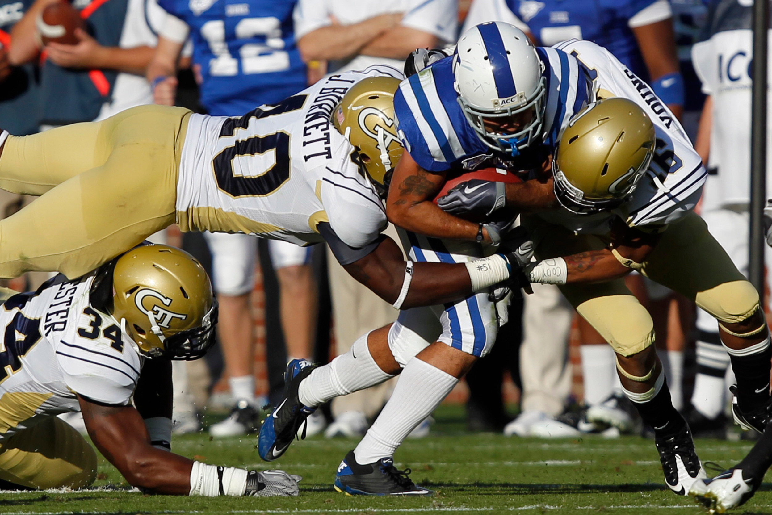 Nov 20, 2010; Atlanta, GA, USA; Duke Blue Devils linebacker Kevin Rojas (28) gets tackled by Georgia Tech Yellow Jackets cornerback Louis Young (16), linebacker Julian Burnett (40) and linebacker Steven Sylvester (34) during the third quarter at Bobby Dodd Stadium. Georgia Tech defeated Duke 30-20. Mandatory Credit: Josh D. Weiss-US PRESSWIRE
