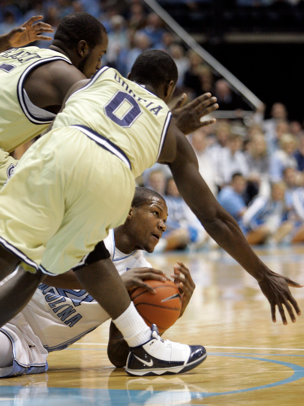 North Carolina's Deon Thompson, bottom, looks to pass as Georgia Tech's Zachery Peacock, left, and Mfon Udofia (0) defend during the first half of an NCAA college basketball game in Chapel Hill, N.C., Saturday, Jan. 16, 2010. (AP Photo/Gerry Broome)