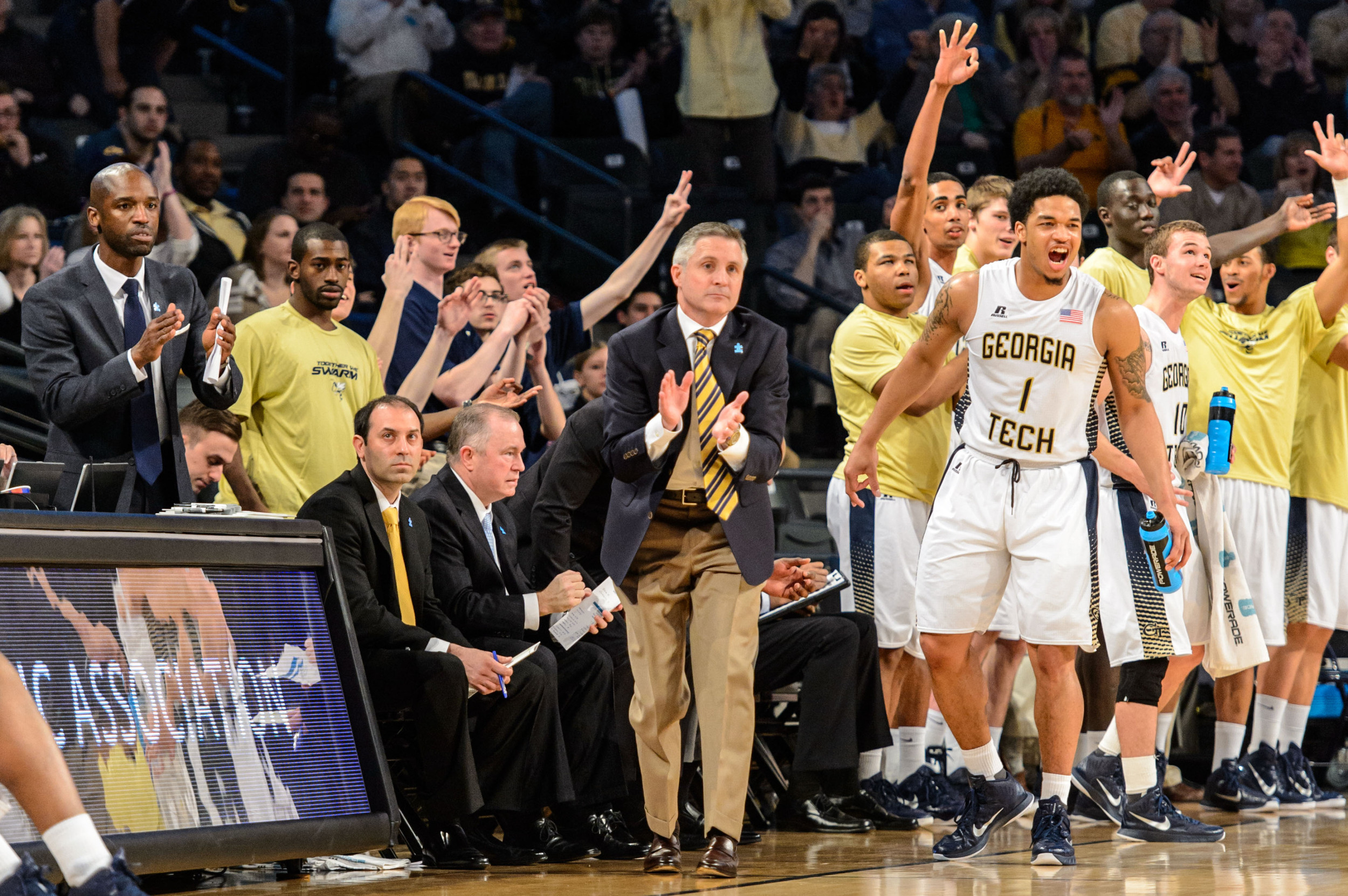 Coach Gregory and the bench react to a play