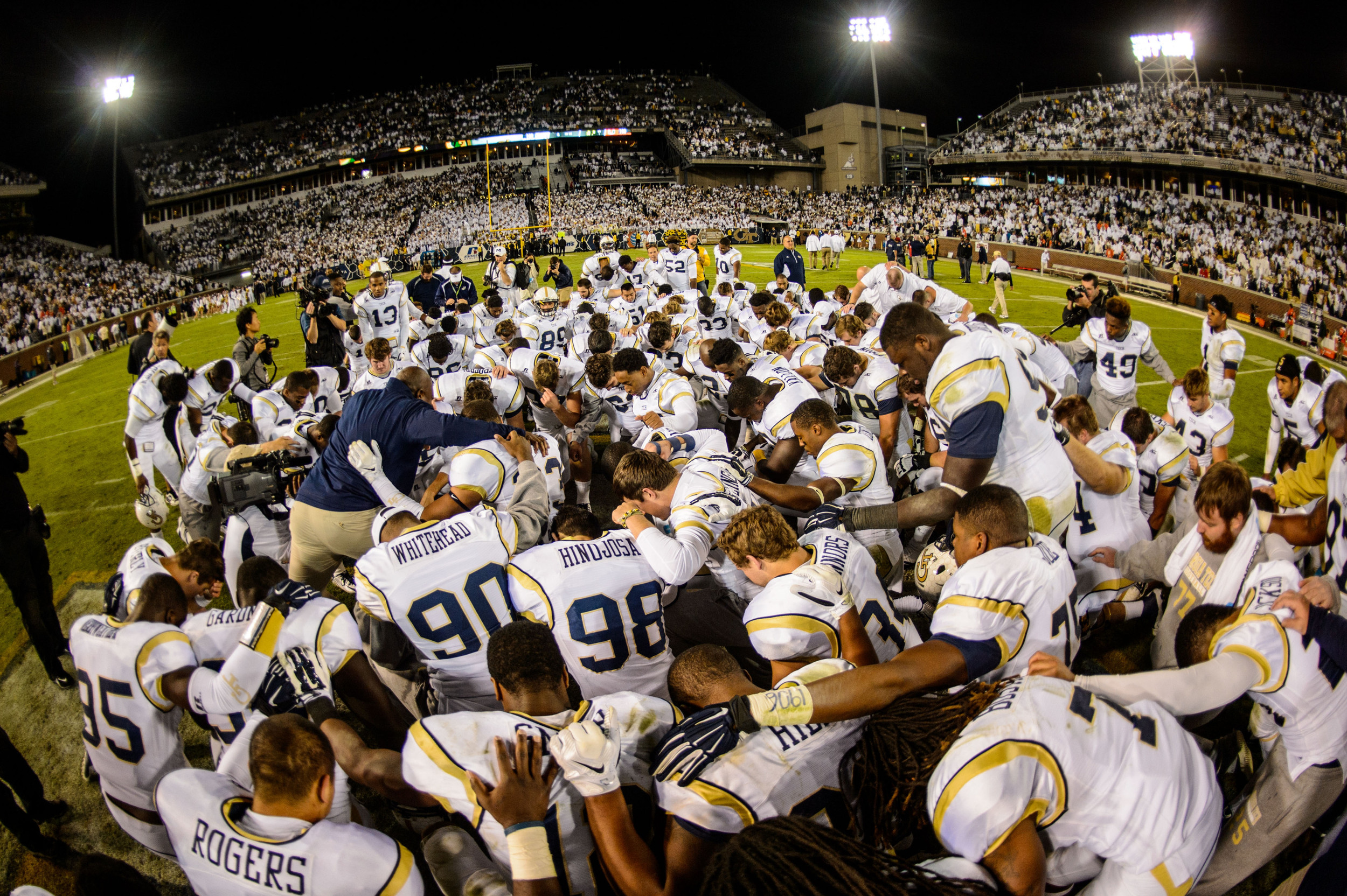 The team prays with Team Chaplain Derrick Moore after the victory
