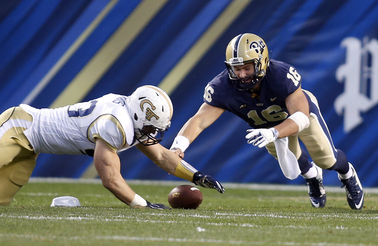 Oct 25, 2014; Pittsburgh, PA, USA; Yellow Jackets linebacker Kyle Travis (left) recovers a fumble by Pittsburgh Panthers quarterback Chad Voytik (16) during the fourth quarter. Charles LeClaire-USA TODAY Sports