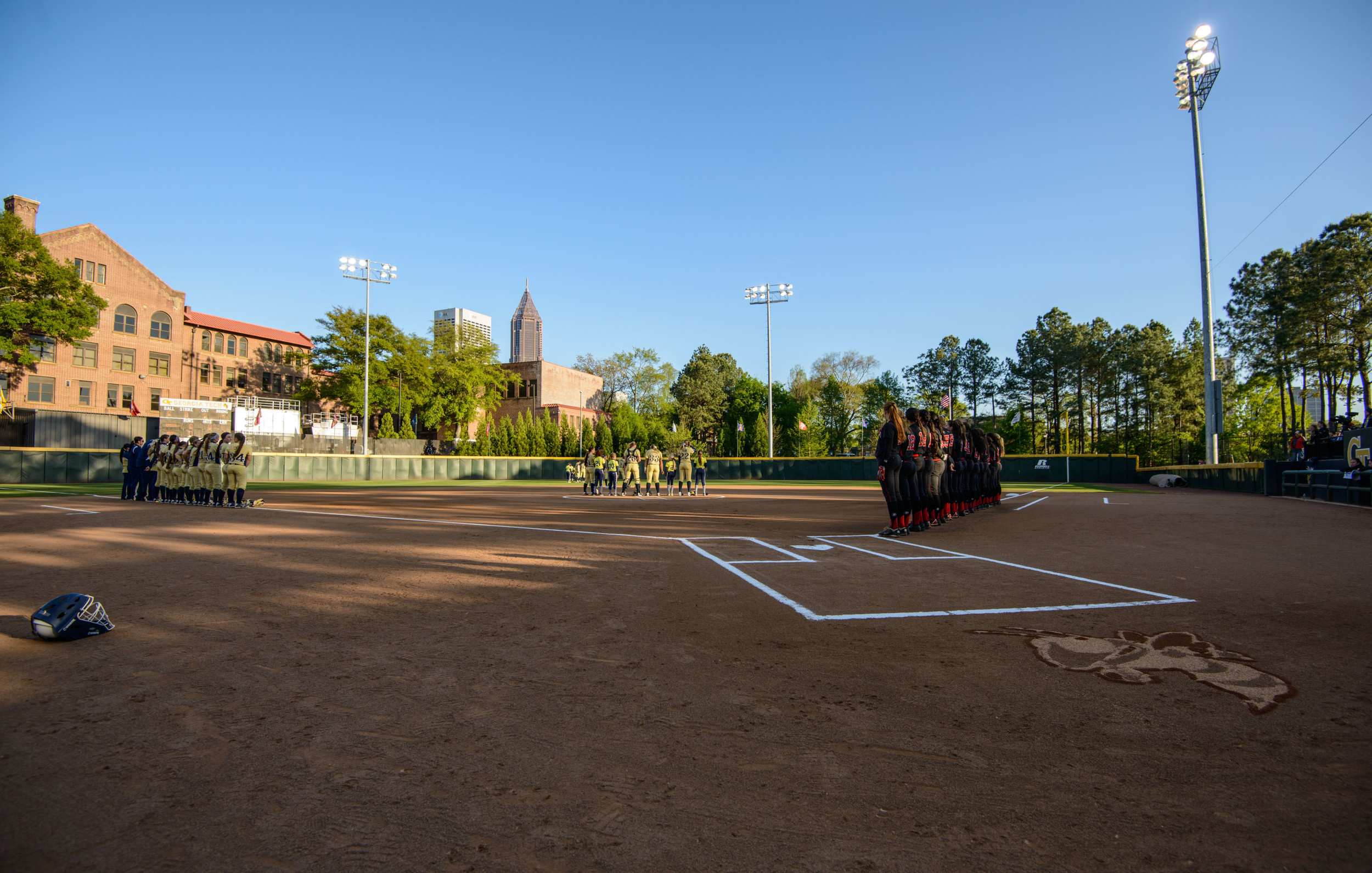 The teams line the bases for the national anthem