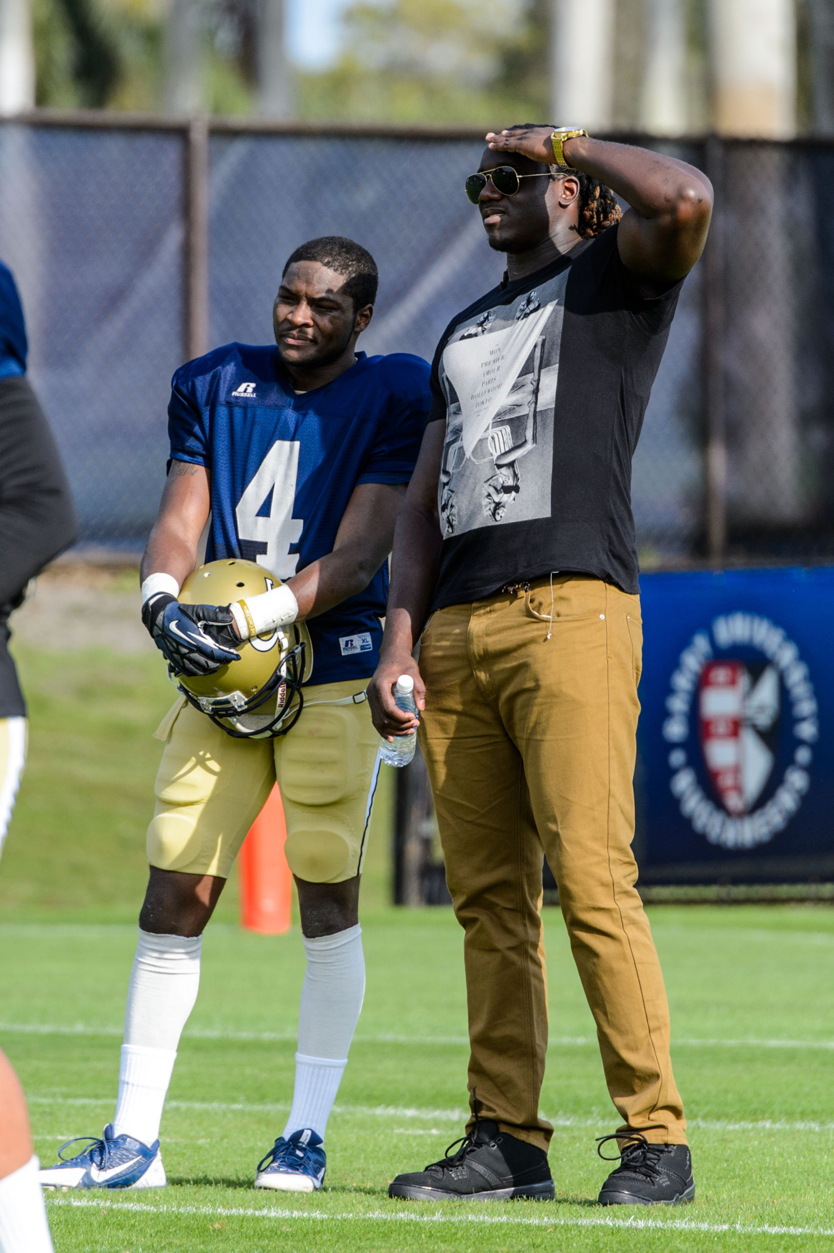 Jamal Golden (4) chats with former Yellow Jacket and current Miami Dolphin Defensive End Emmanuel Dieke