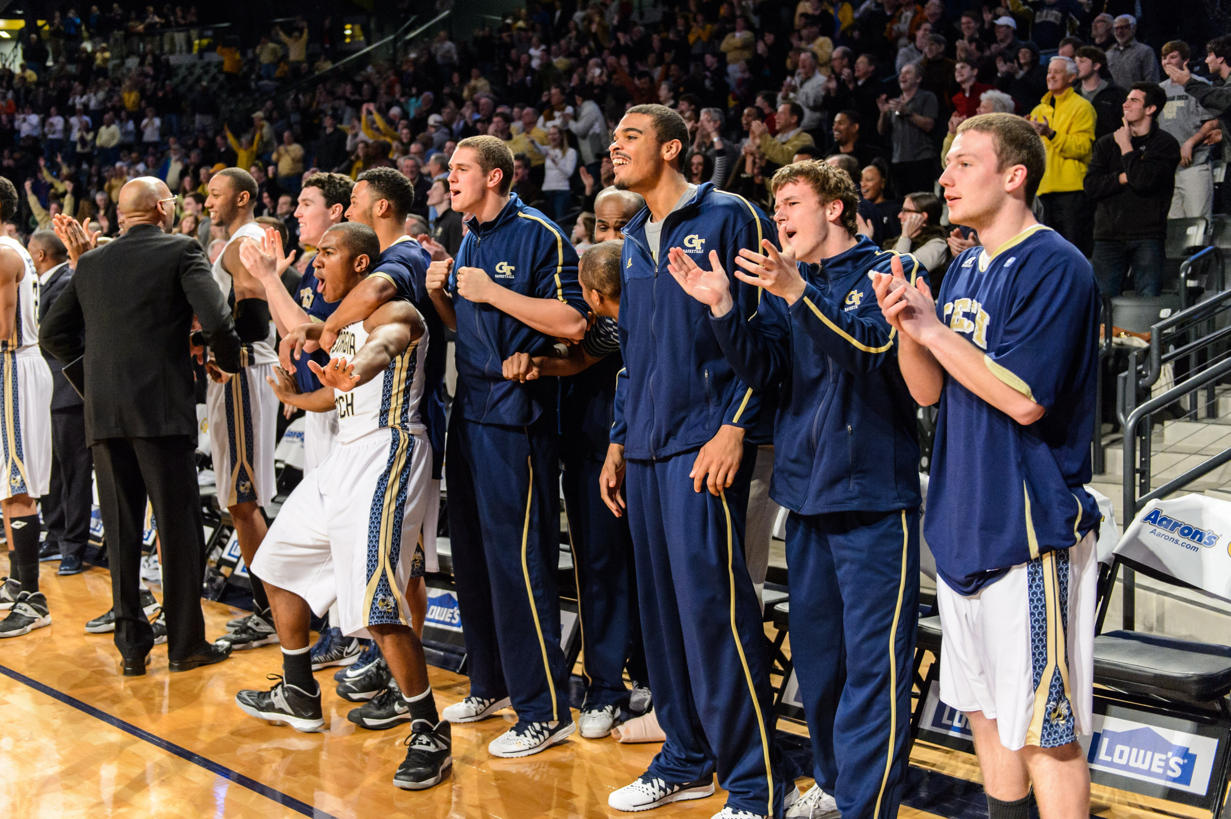 The bench reacts to Marcus Georges-Hunt's 3-pointer
