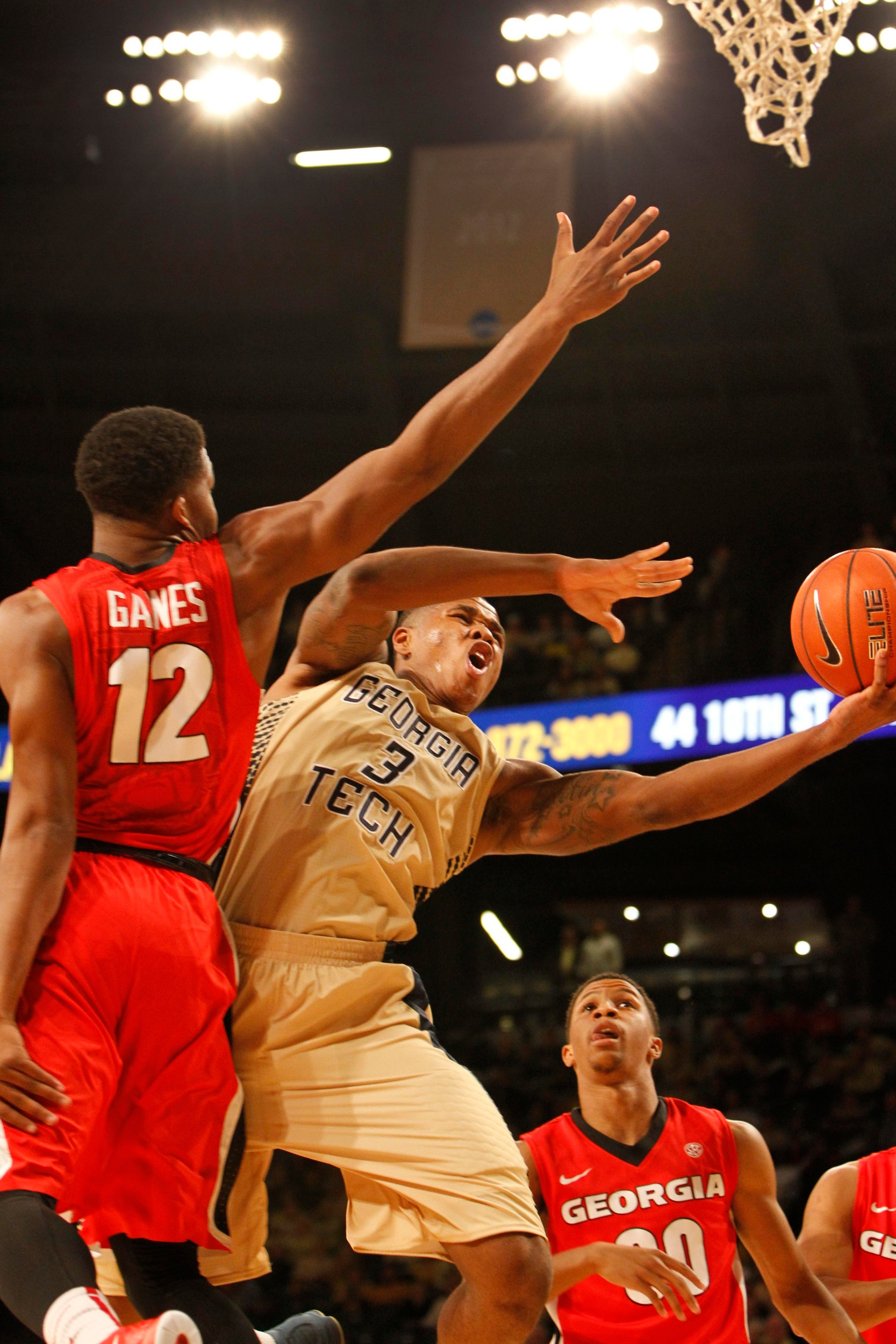 Nov 14, 2014; Atlanta, GA, USA; Georgia Tech Yellow Jackets forward Marcus Georges-Hunt (3) shoots the ball past Georgia Bulldogs guard Kenny Gaines (12) in the first half at McCamish Pavilion.