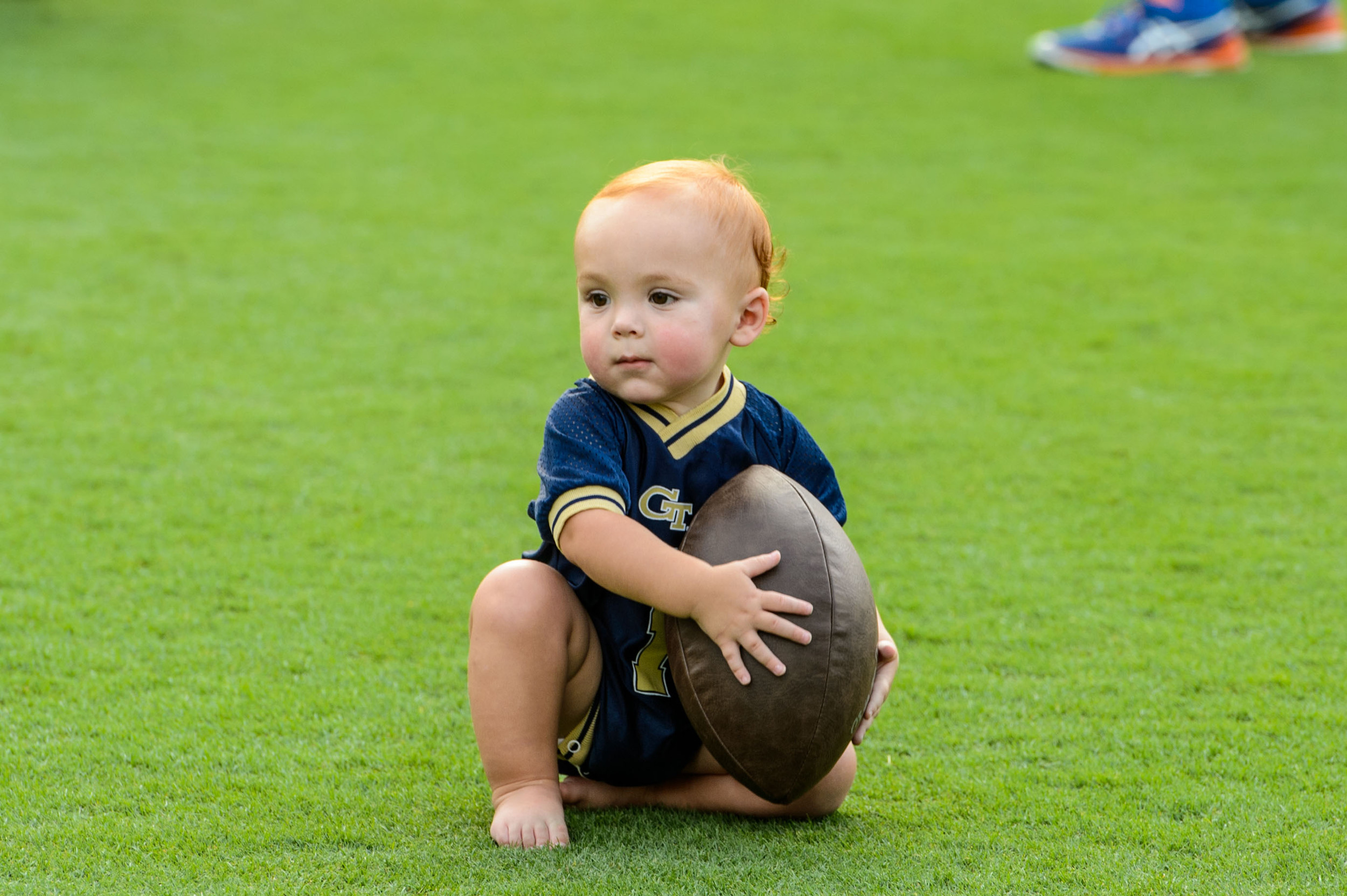 A young Yellow Jacket fan poses with a football