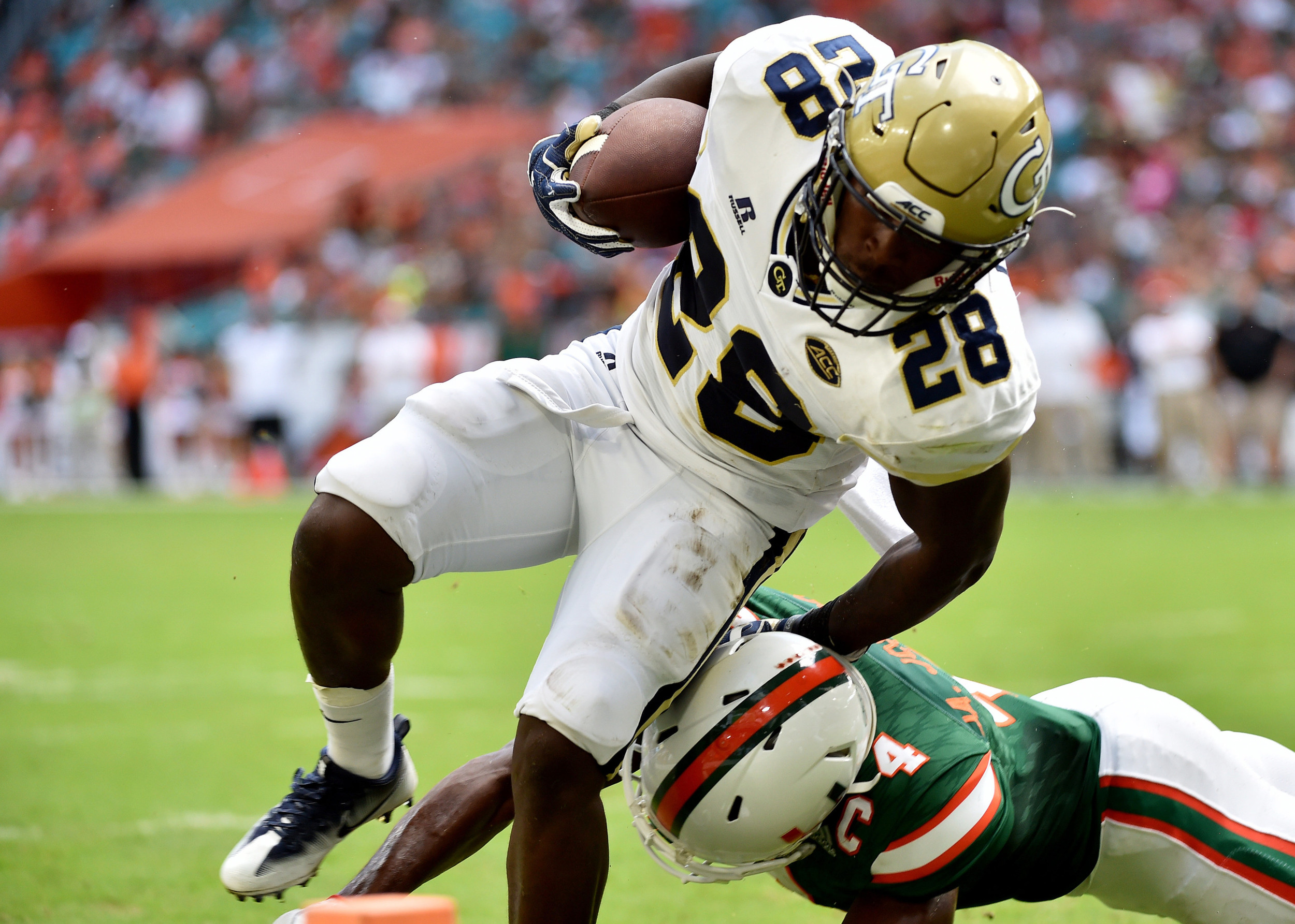 Yellow Jackets running back J.J. Green (28) scores a touchdown as Miami Hurricanes defensive back Jaquan Johnson (4) Steve Mitchell-USA TODAY Sports