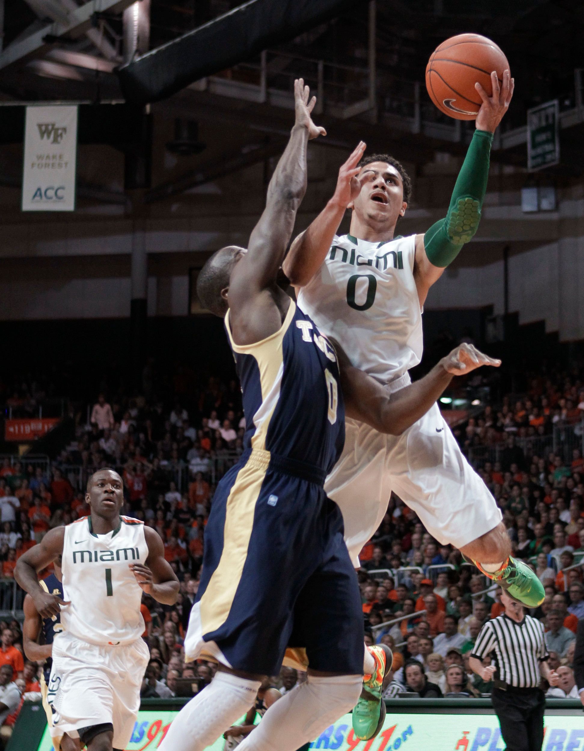 Miami's Shane Larkin (0) is fouled by Georgia Tech's Mfon Udofia. (AP Photo/Luis M. Alvarez)