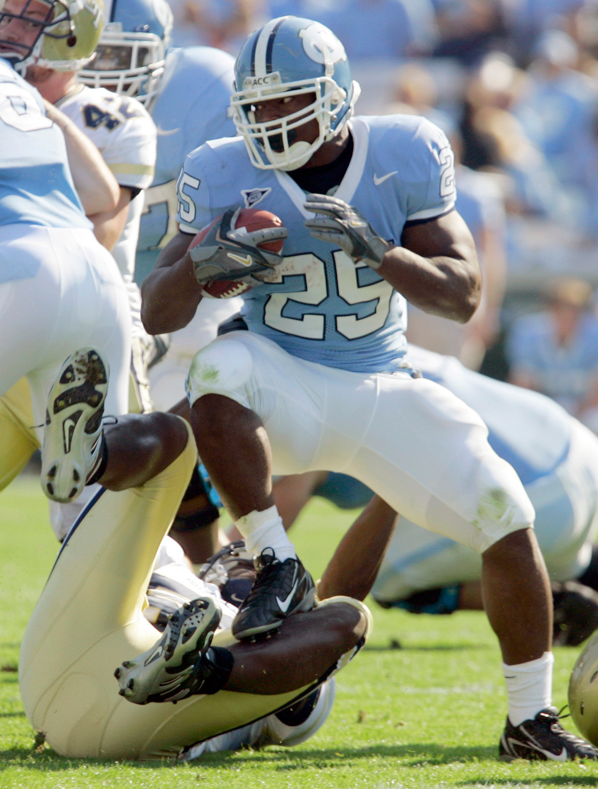 North Carolina's Ronnie McGill (25) steps over Georgia Tech's Philip Wheeler while carrying the ball during the first half of a college football game in Chapel Hill, N.C., Saturday, Nov. 11, 2006. (AP Photo/Gerry Broome)