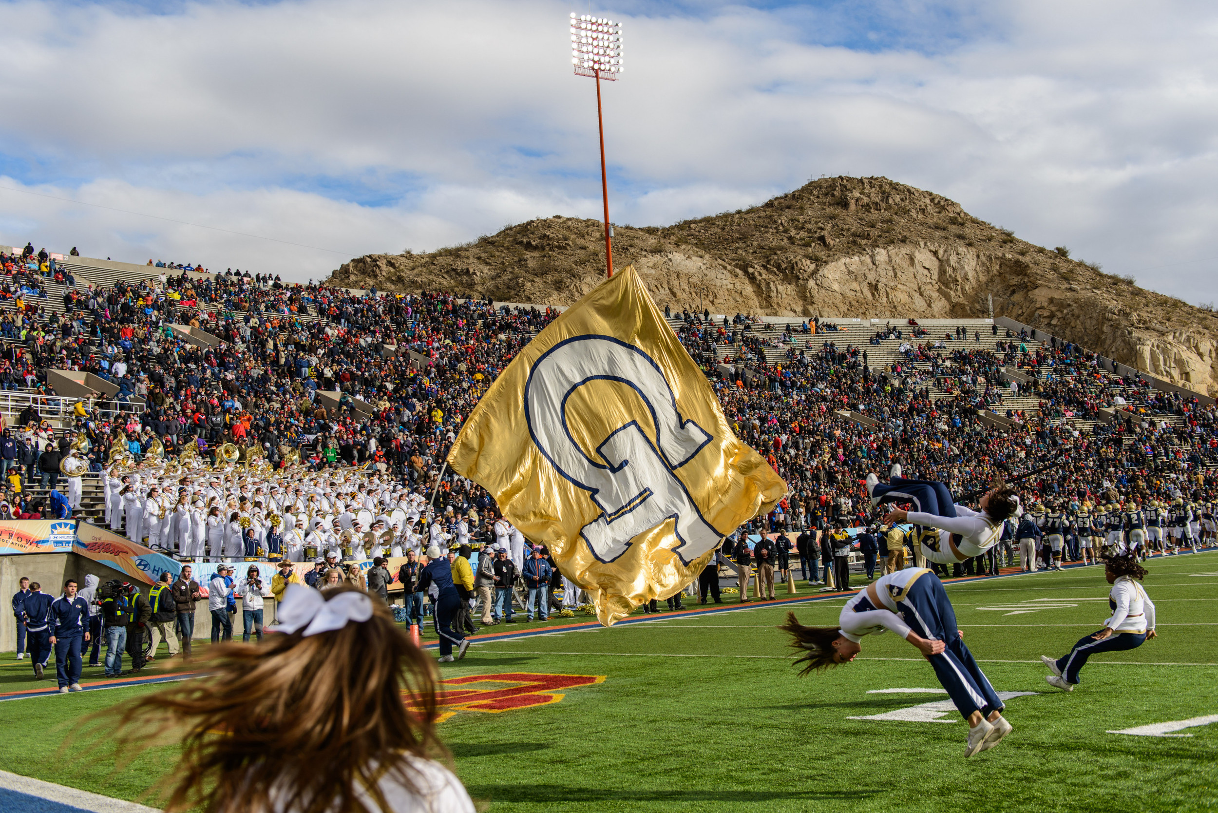 The GT Cheerleaders run the GT flag in the endzone after a touchdown.