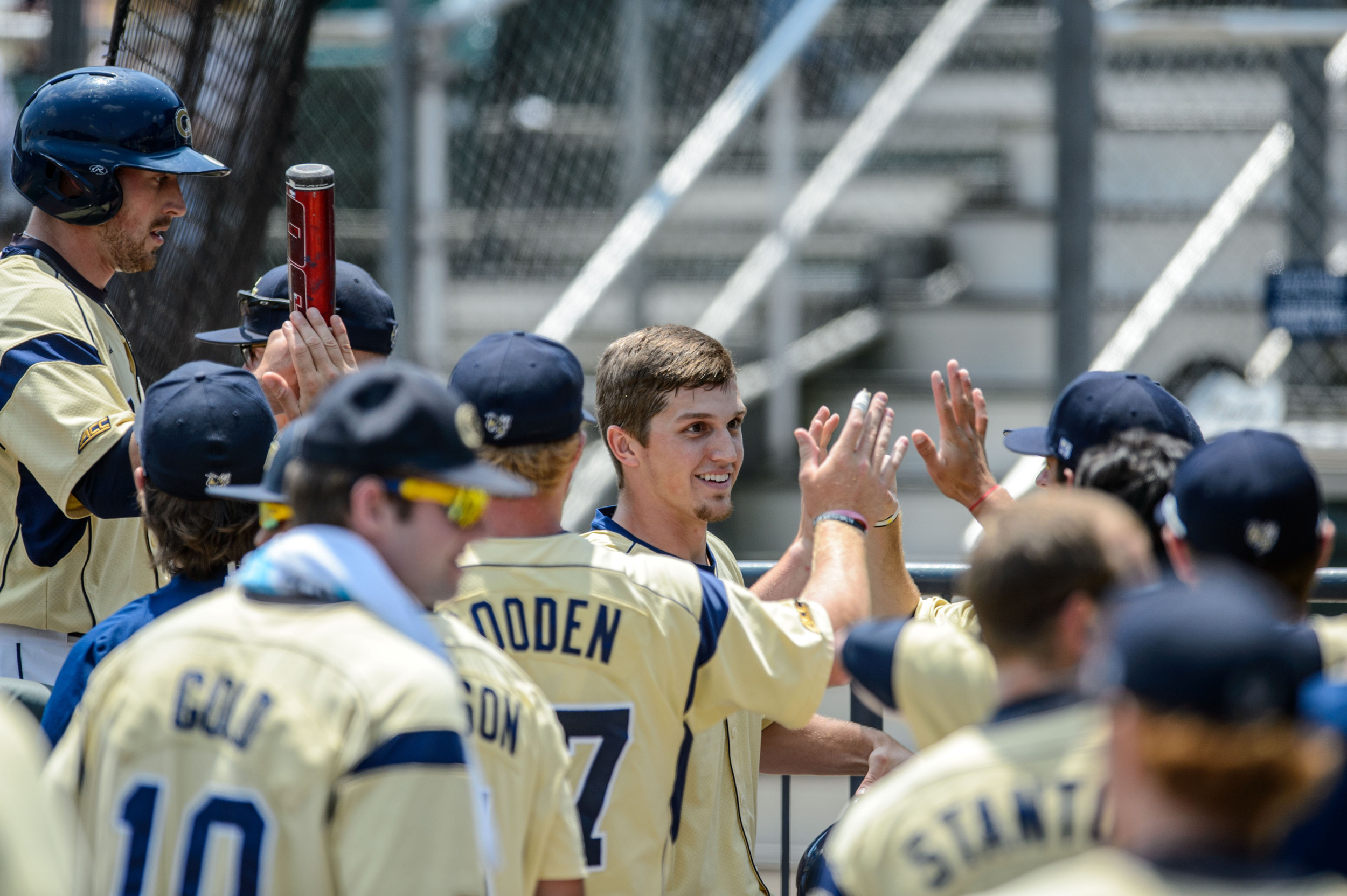 Kel Johnson (25) and A.J. Murray (9) are welcomed back to the dugout after scoring