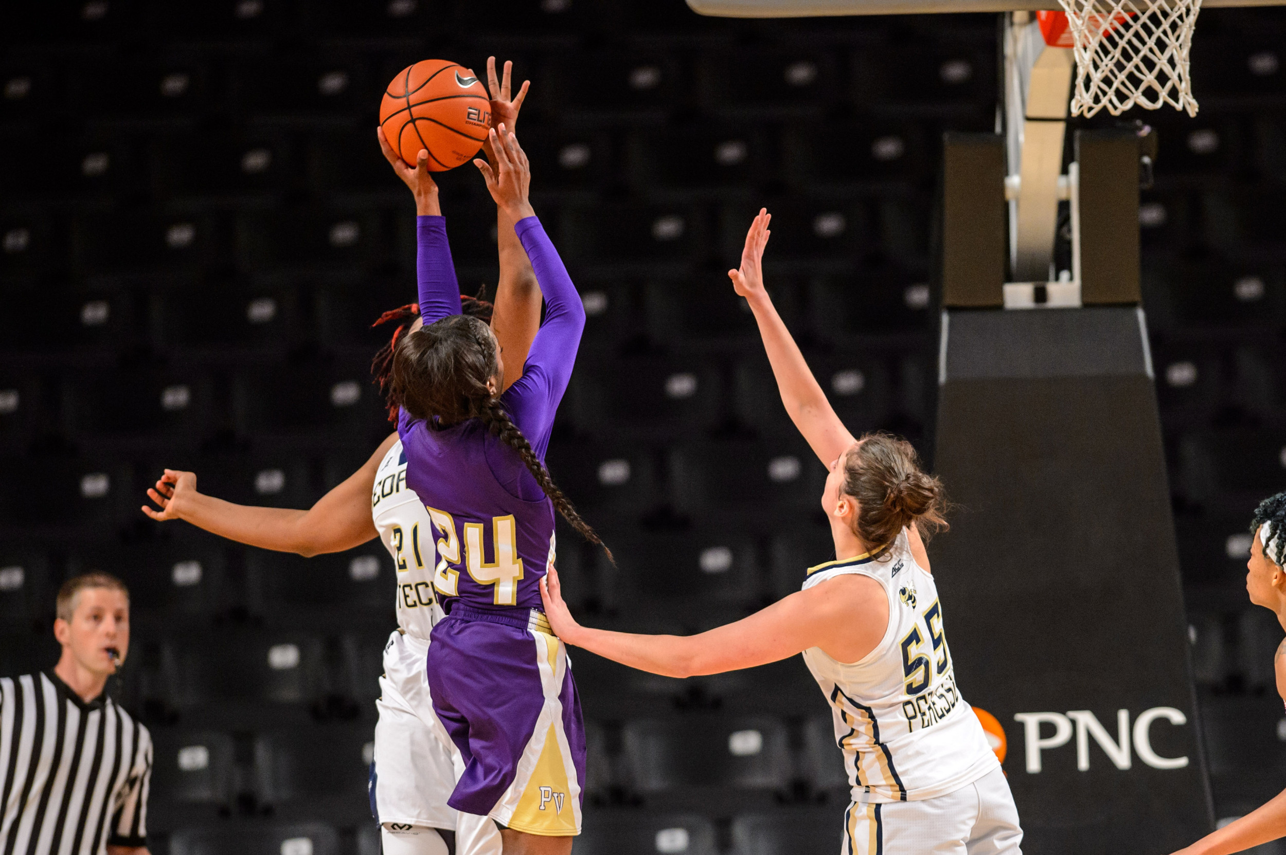 Zaire O'Neil (21) blocks a shot while Antonia Peresson (55) provides pressure