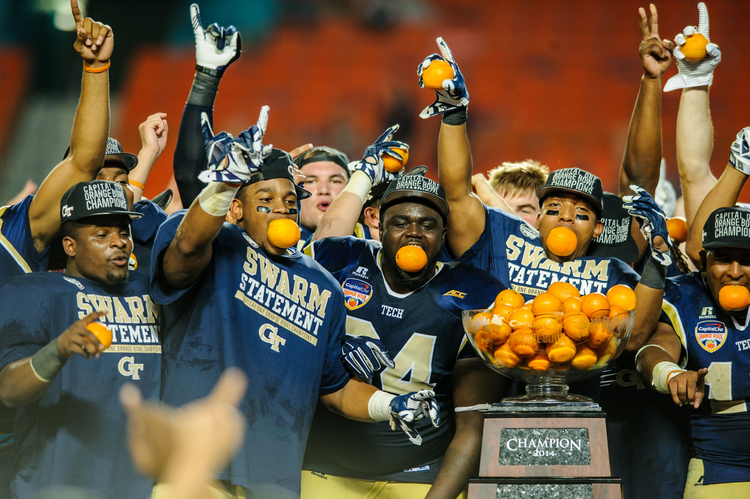 Georgia Tech players celebrate with the Orange Bowl trophy