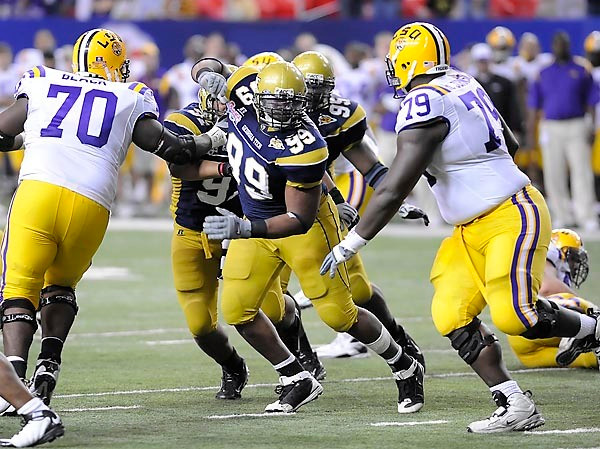 Vance Walker (99) tries to break through the LSU protection. Photo by LensEffects
