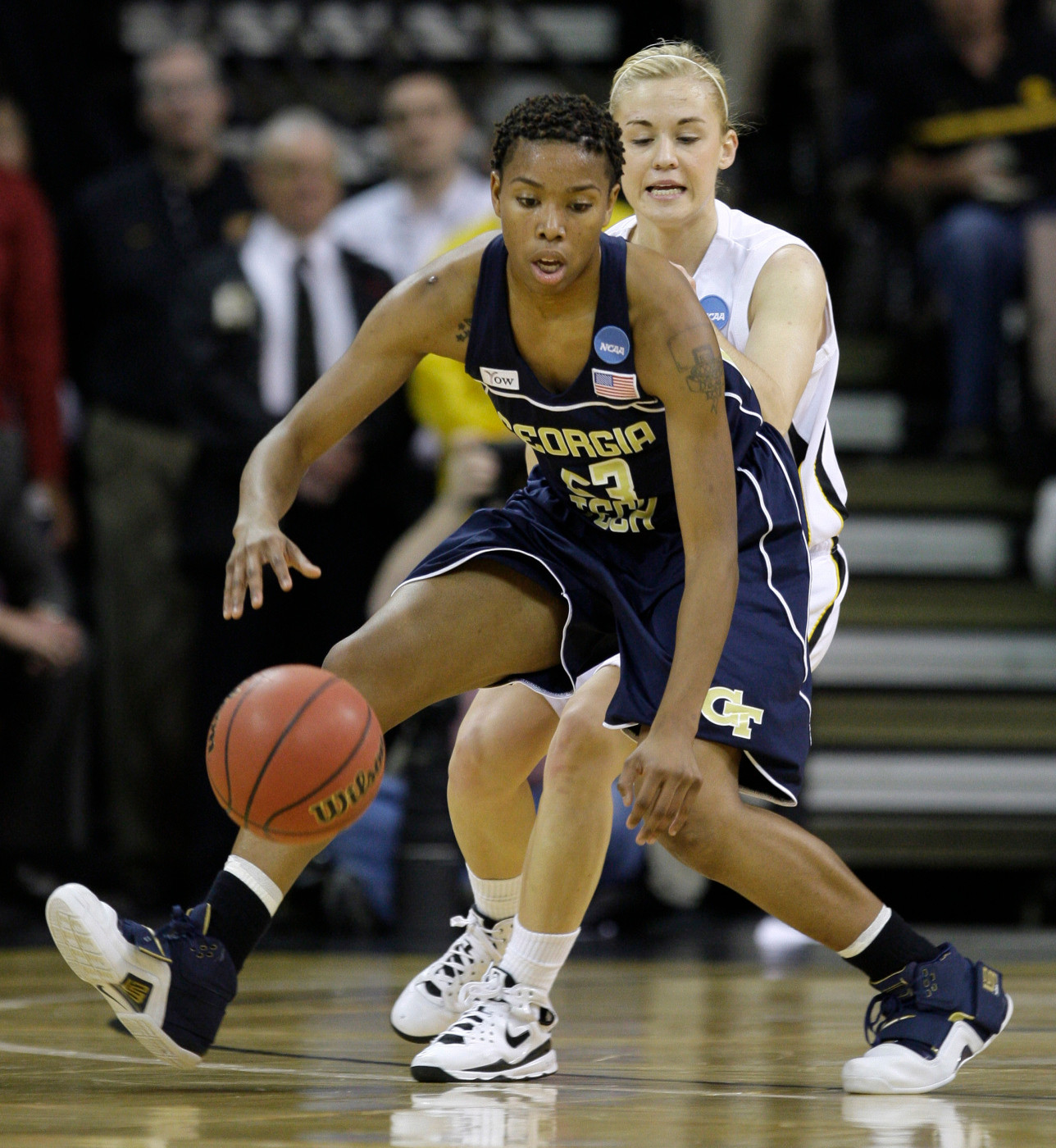 Deja Foster picks up a loose ball in front of Kamille Wahlin during the first half.
