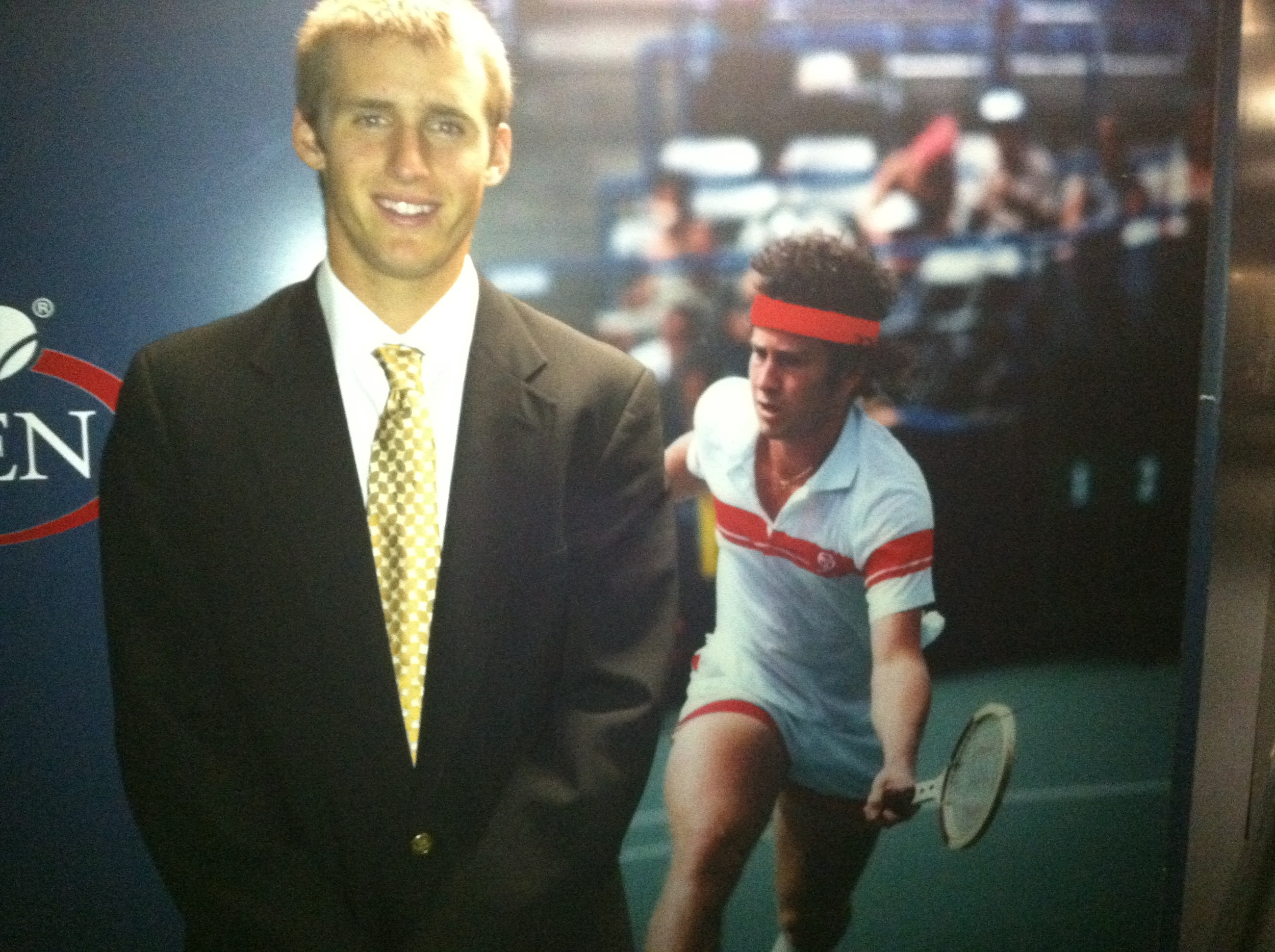 Kevin King posing with a picture of John McEnroe