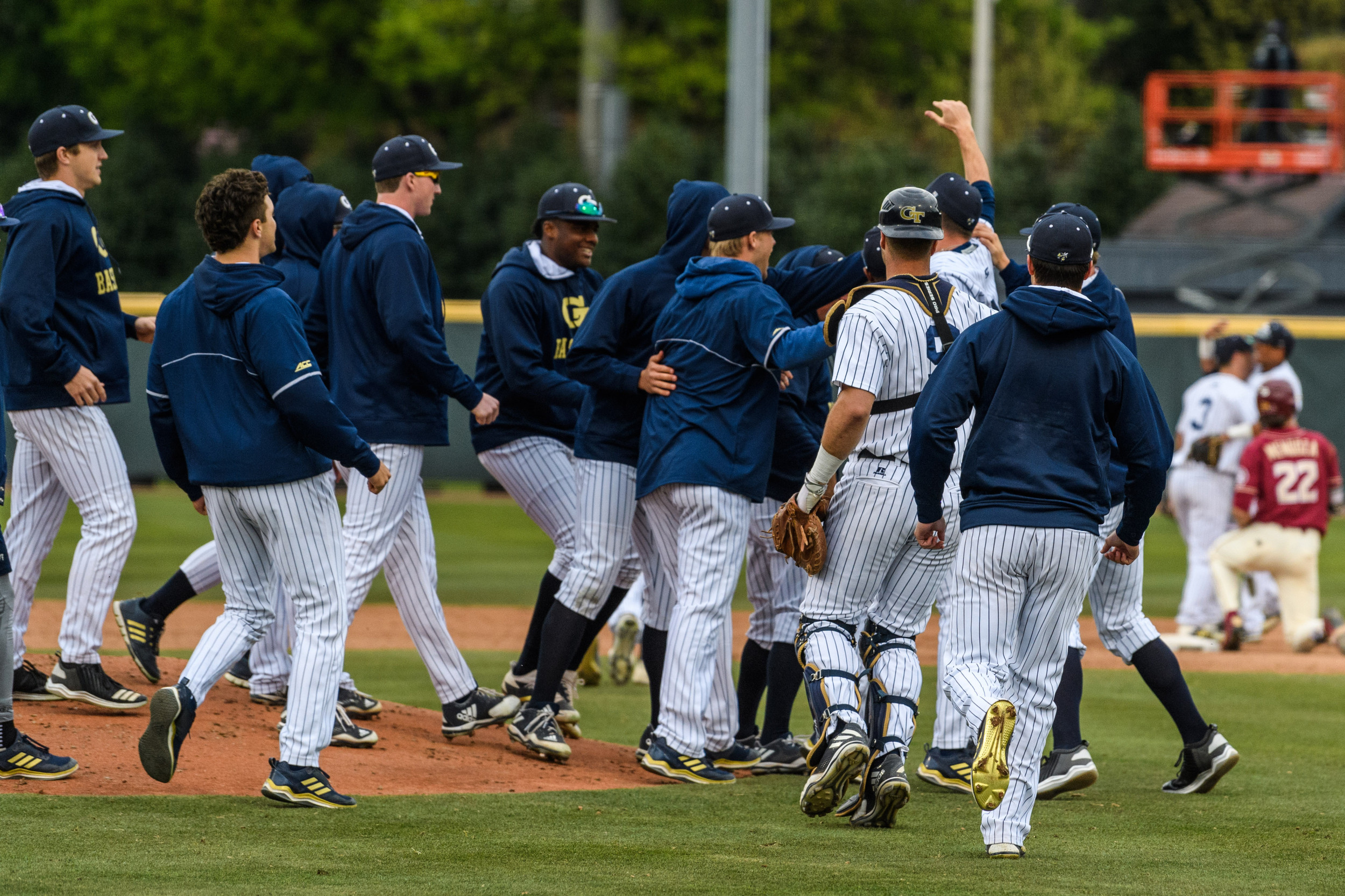 The team swarms Connor Thomas (42) after his complete game