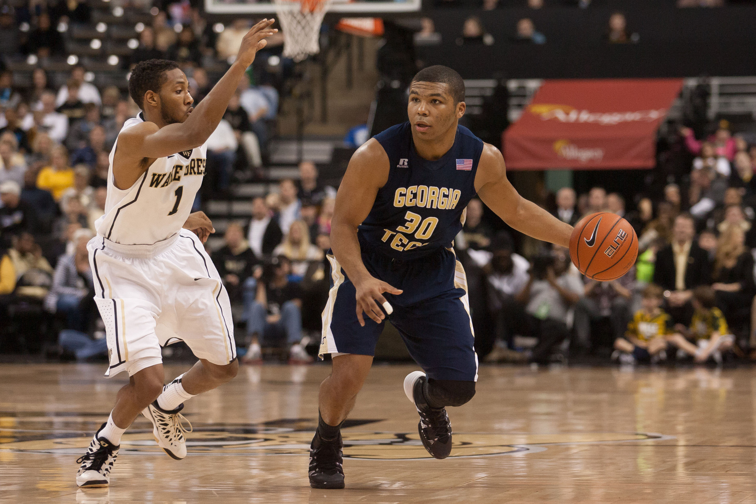Feb 1, 2014; Winston-Salem, NC, USA; Yellow Jackets guard Corey Heyward (30) drives the ball around Wake Forest Demon Deacons guard Madison Jones (1) during the second half. Jeremy Brevard-USA TODAY Sports