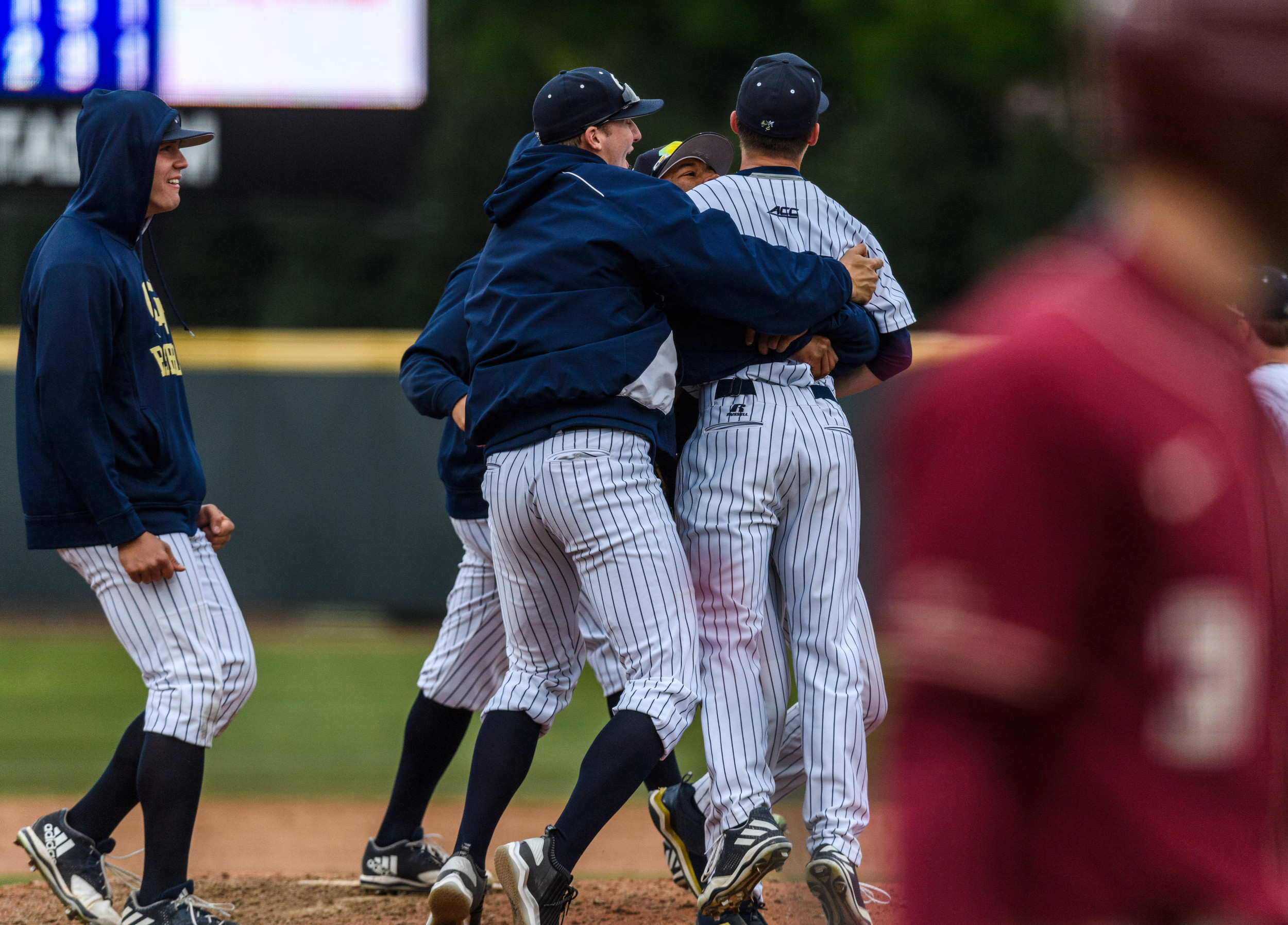 The team swarms Connor Thomas (42) after his complete game