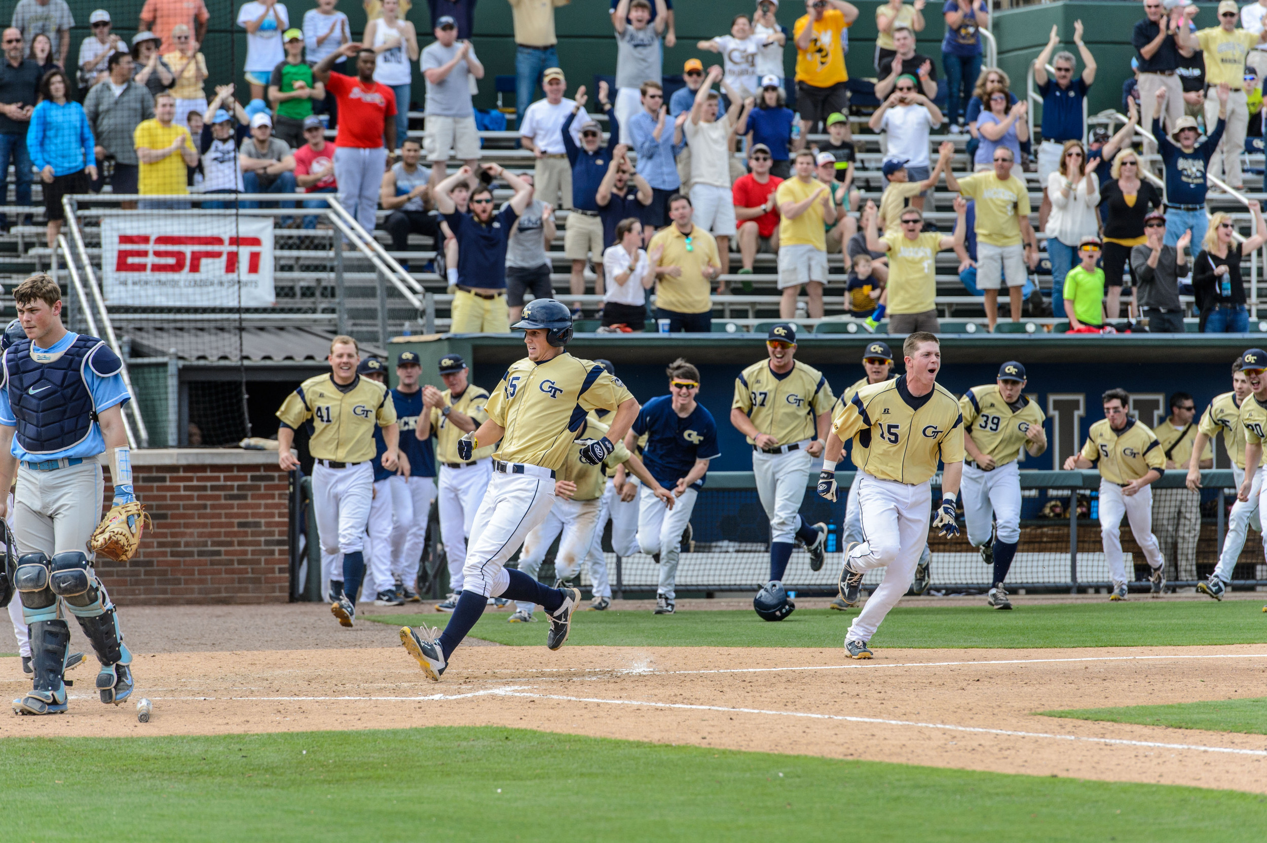 Kel Johnson (25) runs in to score the winning run while the crowd and team celebrate