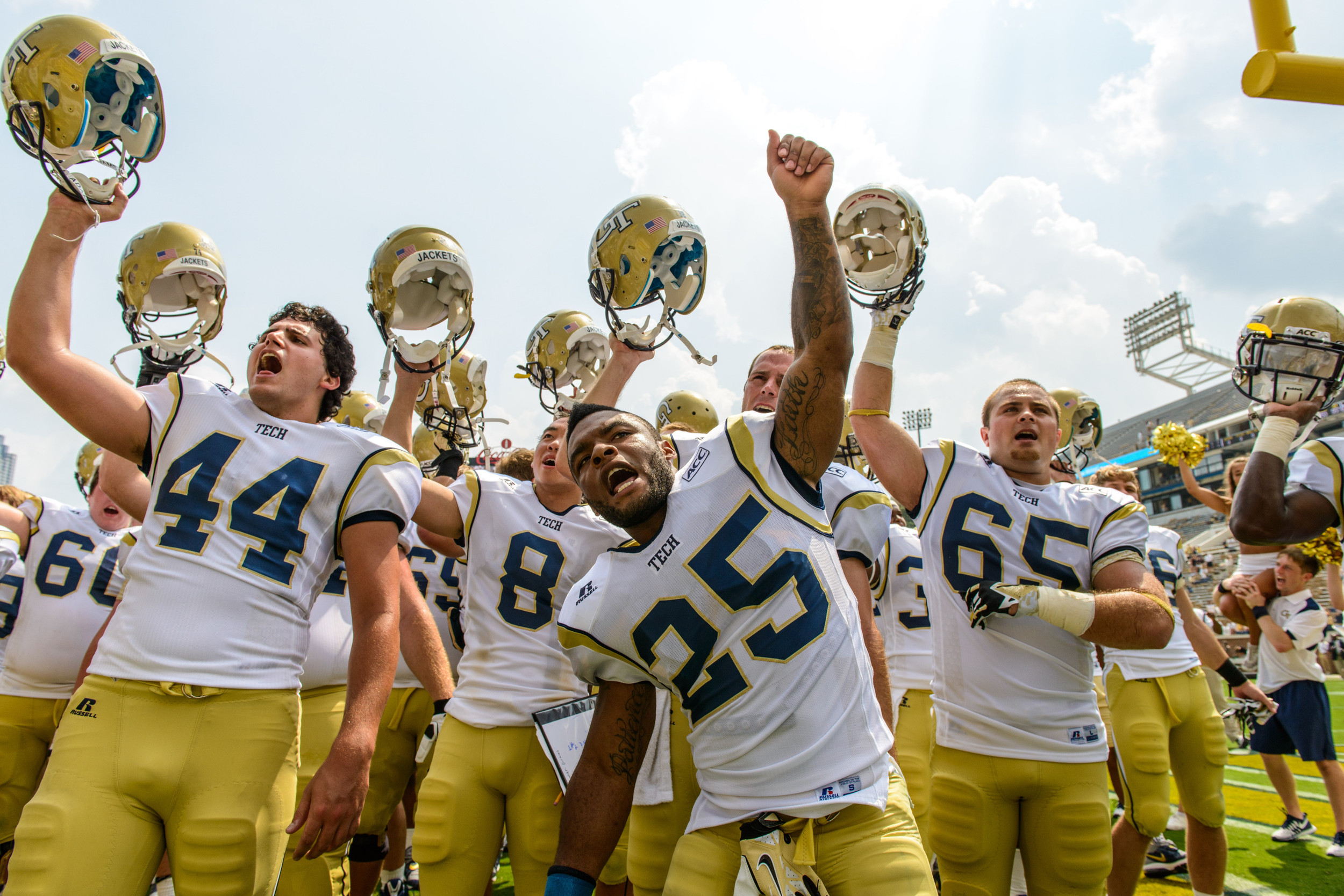 David Scully (44), Robert Godhigh (25), Corey Alford (65), Andrew Chau (8) and the rest of the Yellow Jackets sing the fight song with the students after the win.