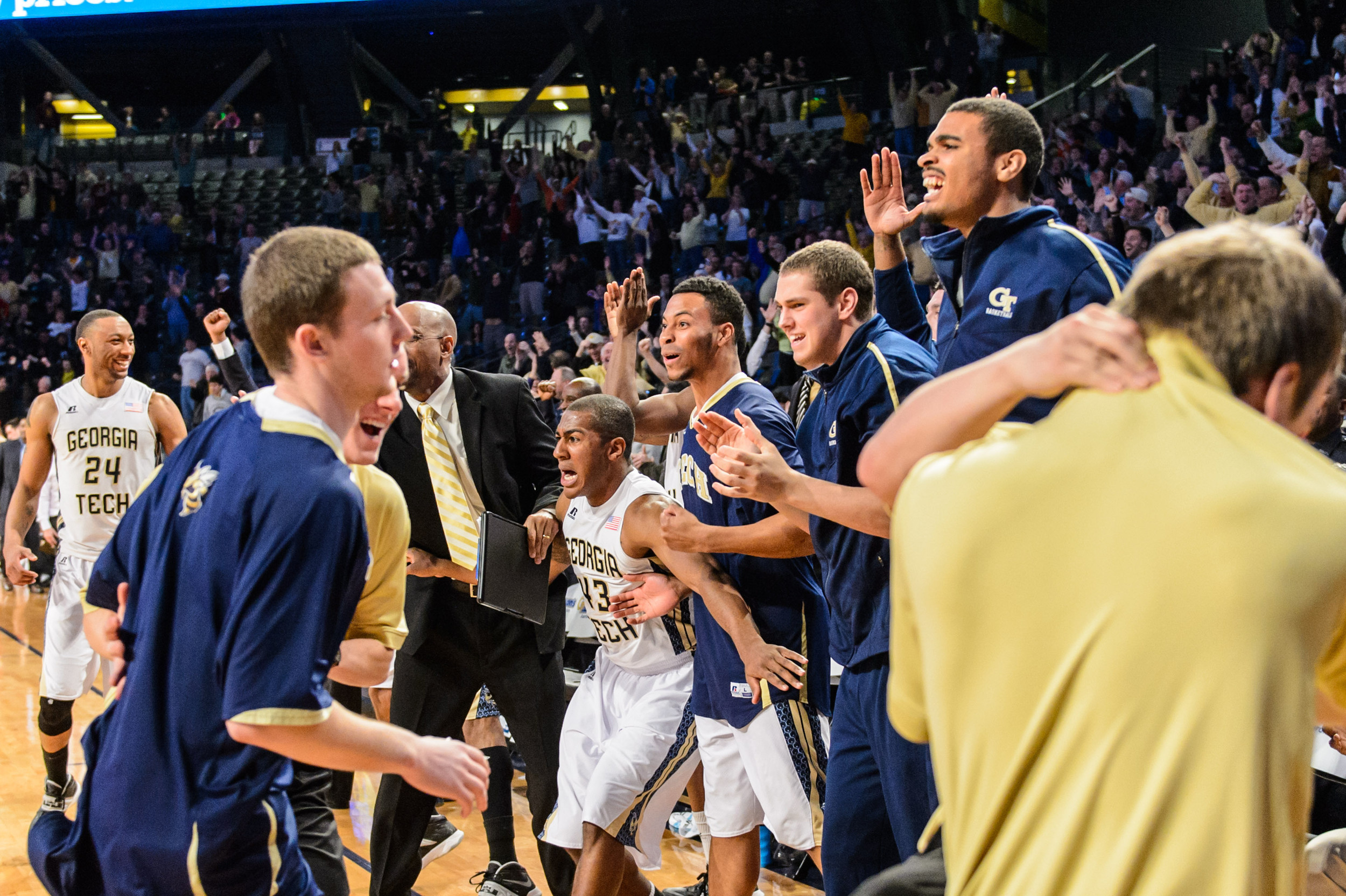 The bench reacts to Marcus Georges-Hunt's 3-pointer