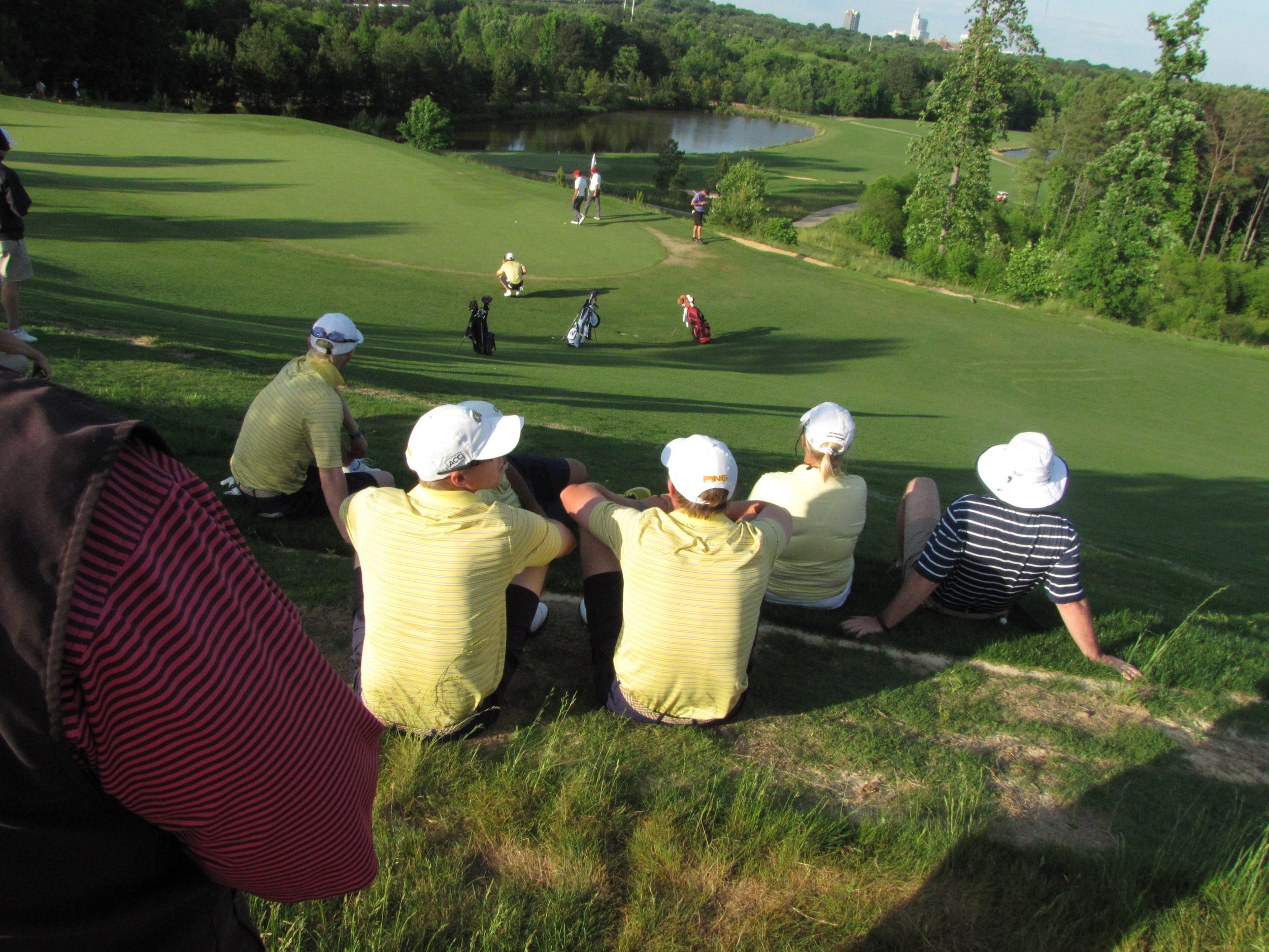 Richy Werenski, Bo Andrews, Anders Albertson watch Seth Reeves finish up his 69 in the second round of the NCAA Raleigh Regional, May 16, 2014