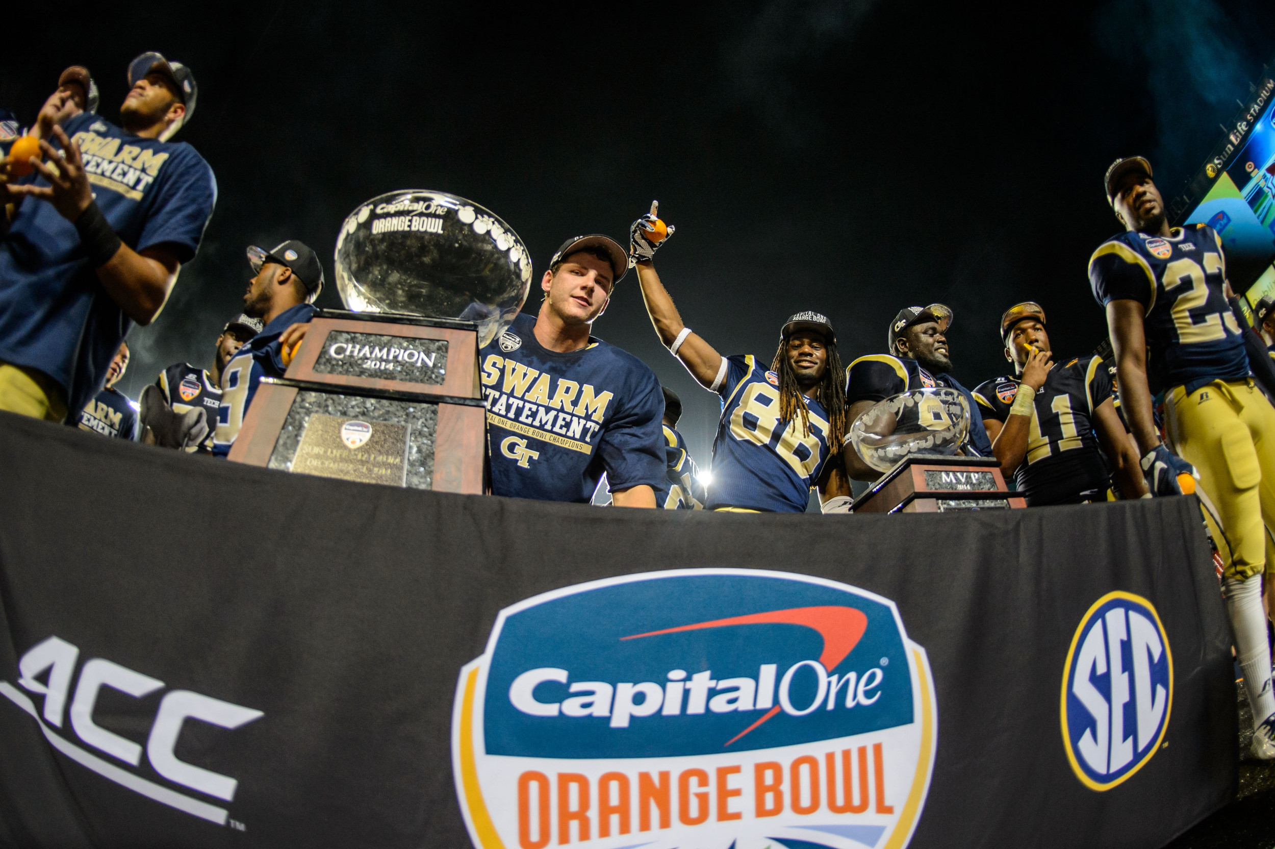 Georgia Tech players celebrate with the Orange Bowl trophy