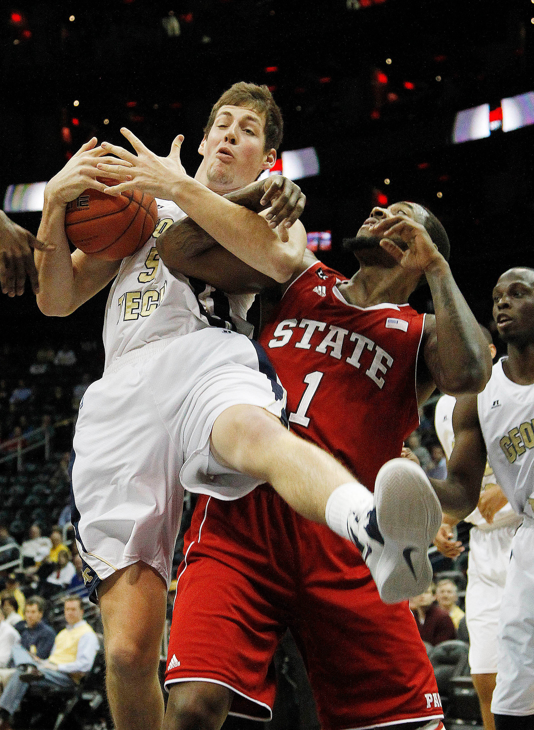 Georgia Tech center Daniel Miller (5) comes down with a rebound over North Carolina State forward Richard Howell (1) during the first half. (AP Photo/John Bazemore)