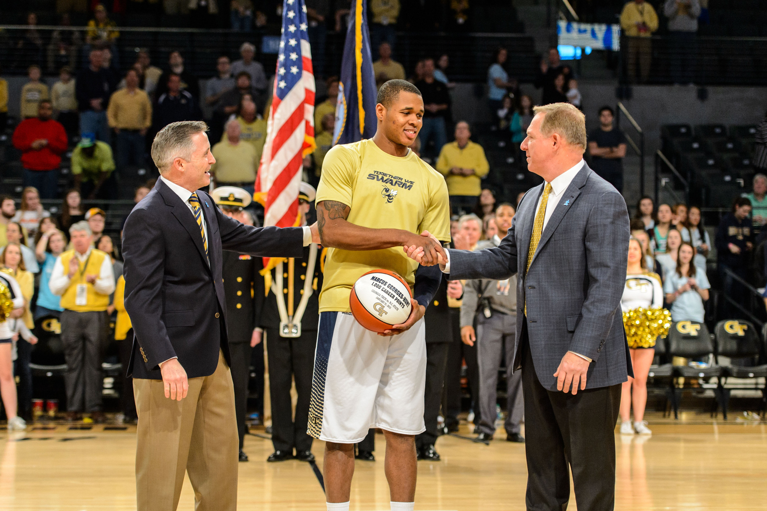 Marcus Georges-Hunt (3) is presented with a commemorative ball for reaching 1000 career points by Coach Brian Gregory and Athletic Director Mike Bobinksi