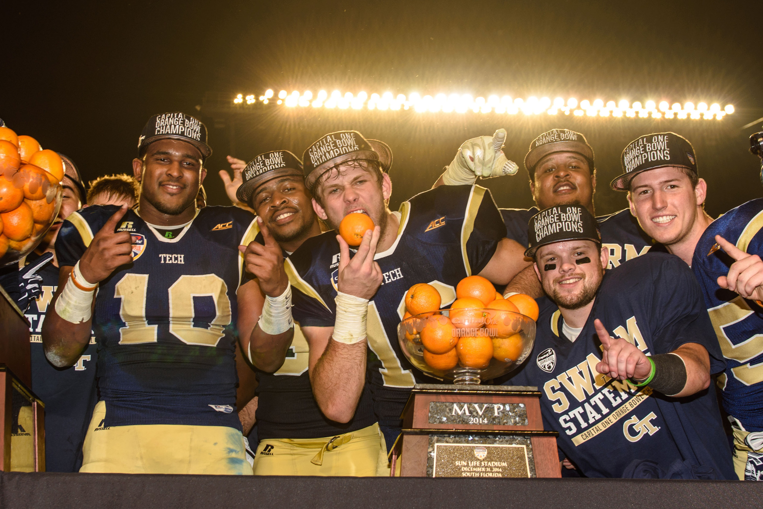 Georgia Tech players celebrate with the Orange Bowl trophy