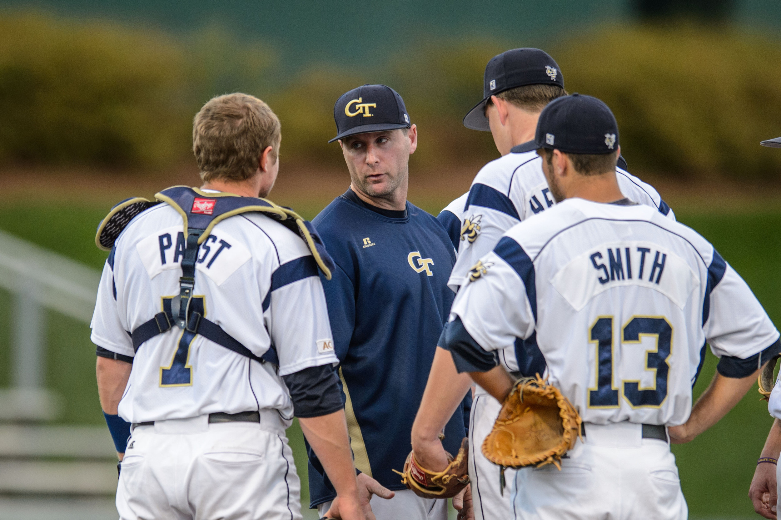 Pitching Coach Jason Howell (34) speaks with Arden Pabst (7) and Josh Heddinger (37)
